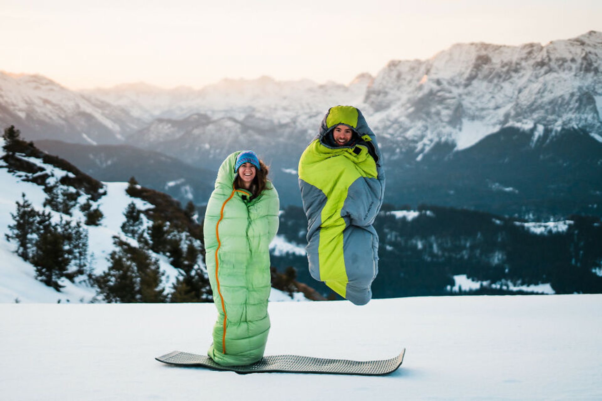 زوجی در کیسه خواب در محیط برفی کوهستان