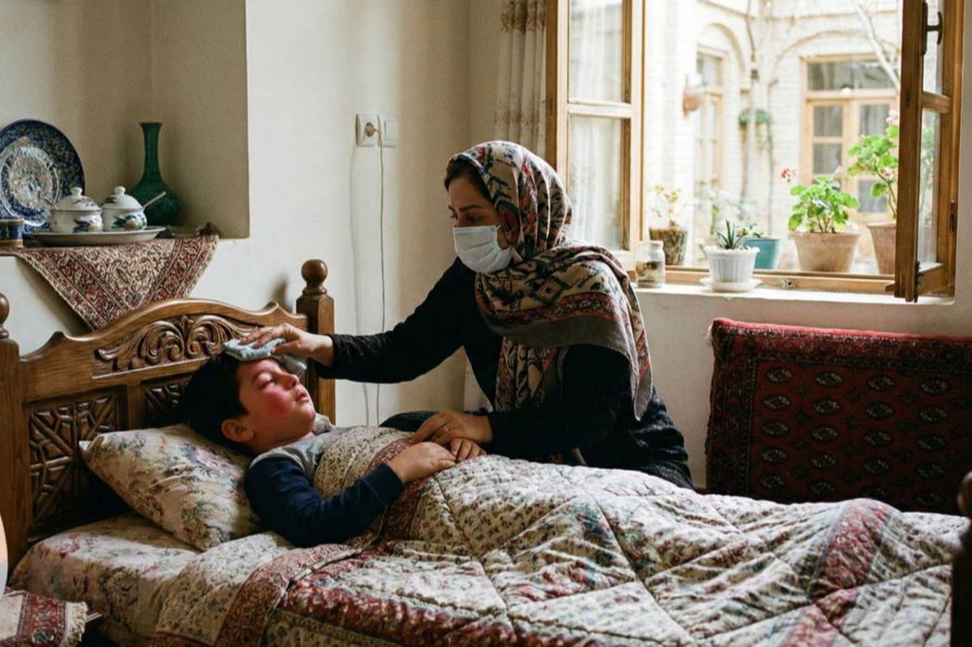 کودک ایرانی با تب بالا در تختخواب در حال استراحت است و مادر ایرانی نگران با ماسک در کنار او نشسته و از او مراقبت می‌کند، در پس‌زمینه نوری ملایم از پنجره به داخل می‌تابد.