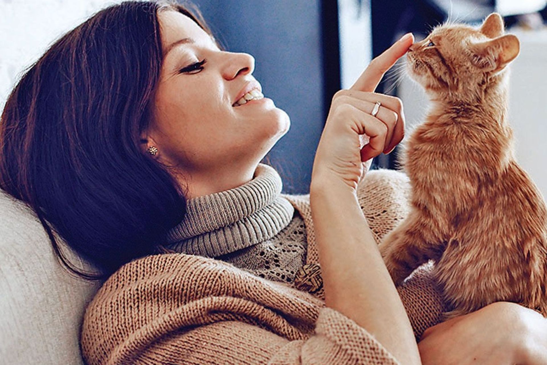 زن جوان گربه خود را در آغوش گرفته است