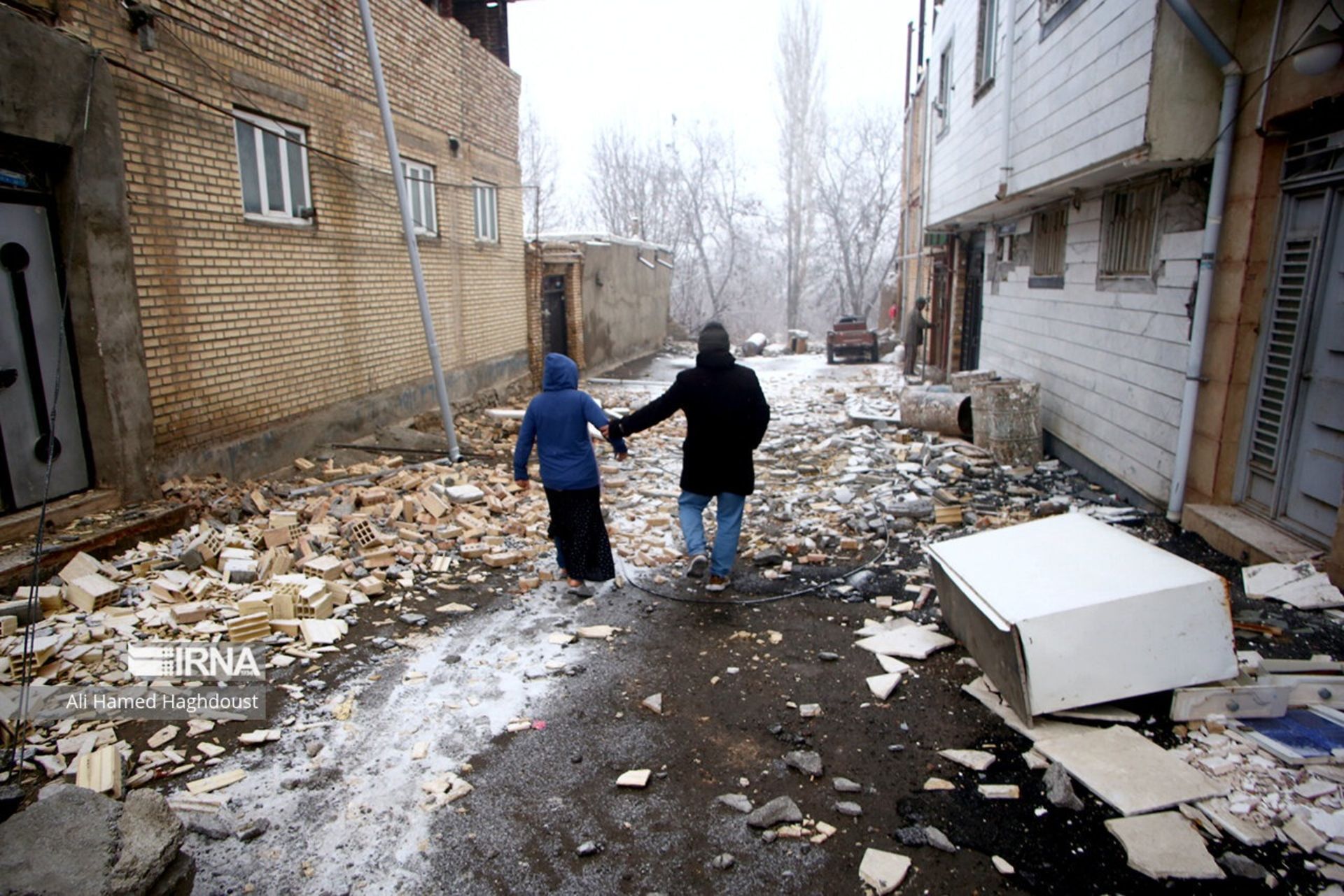 دو عابر در خیابان زمستانی بعد از زمین لرزه خوی