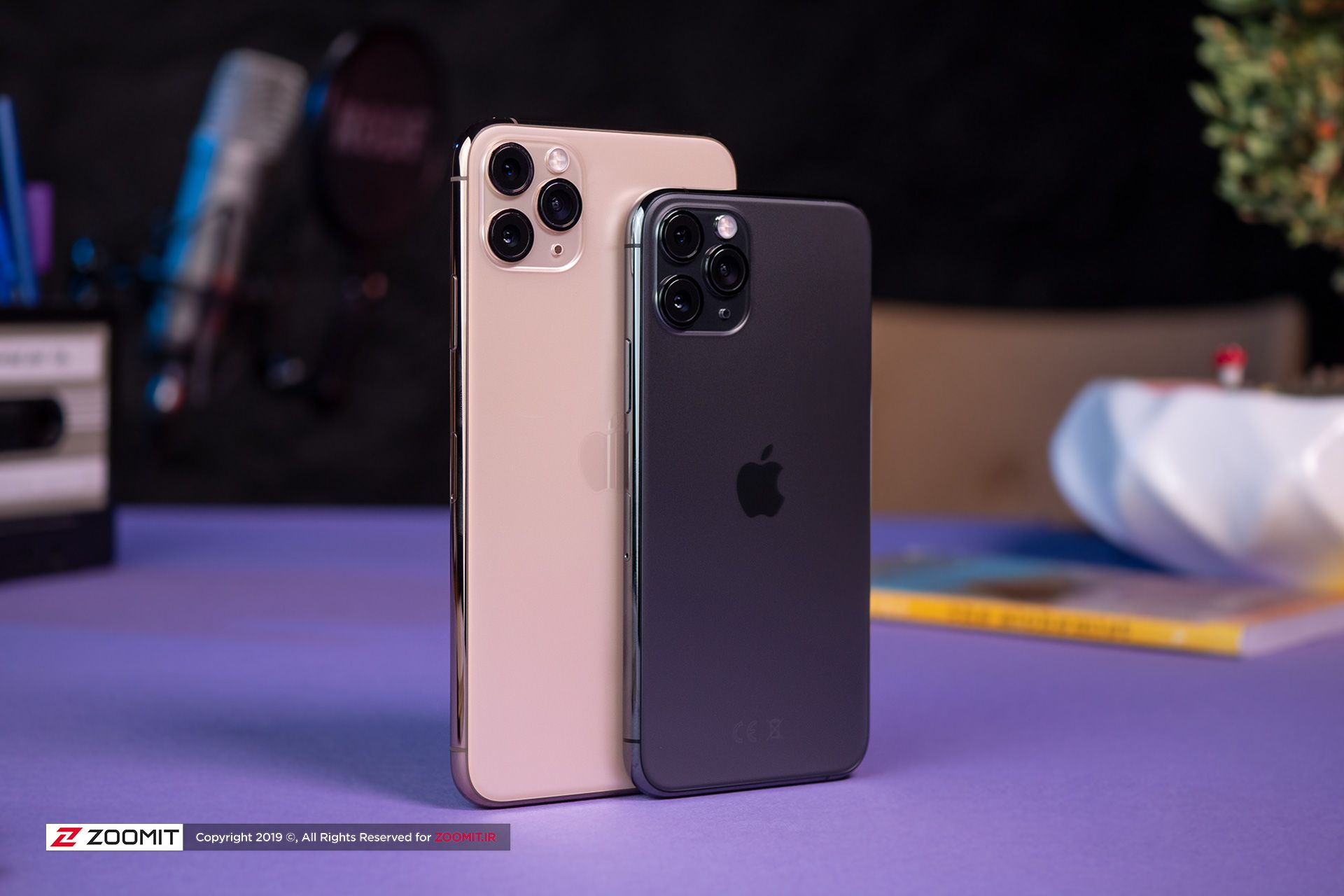 آیفون 11 پرو مکس / iPhone 11 Pro Max در کنار آیفون ۱۱ پرو روی میز رنگ طلایی و خاکستری