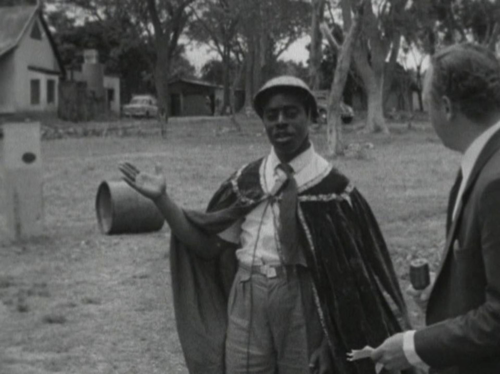 ادوارد ماکوکا ان‌کولوسو (۱۹۱۹-۱۹۸۹) با کلاه‌کاست و لباس نظامی و شنل در هنگام گفت‌وگو با خبرنگار آسوشیتد پرس