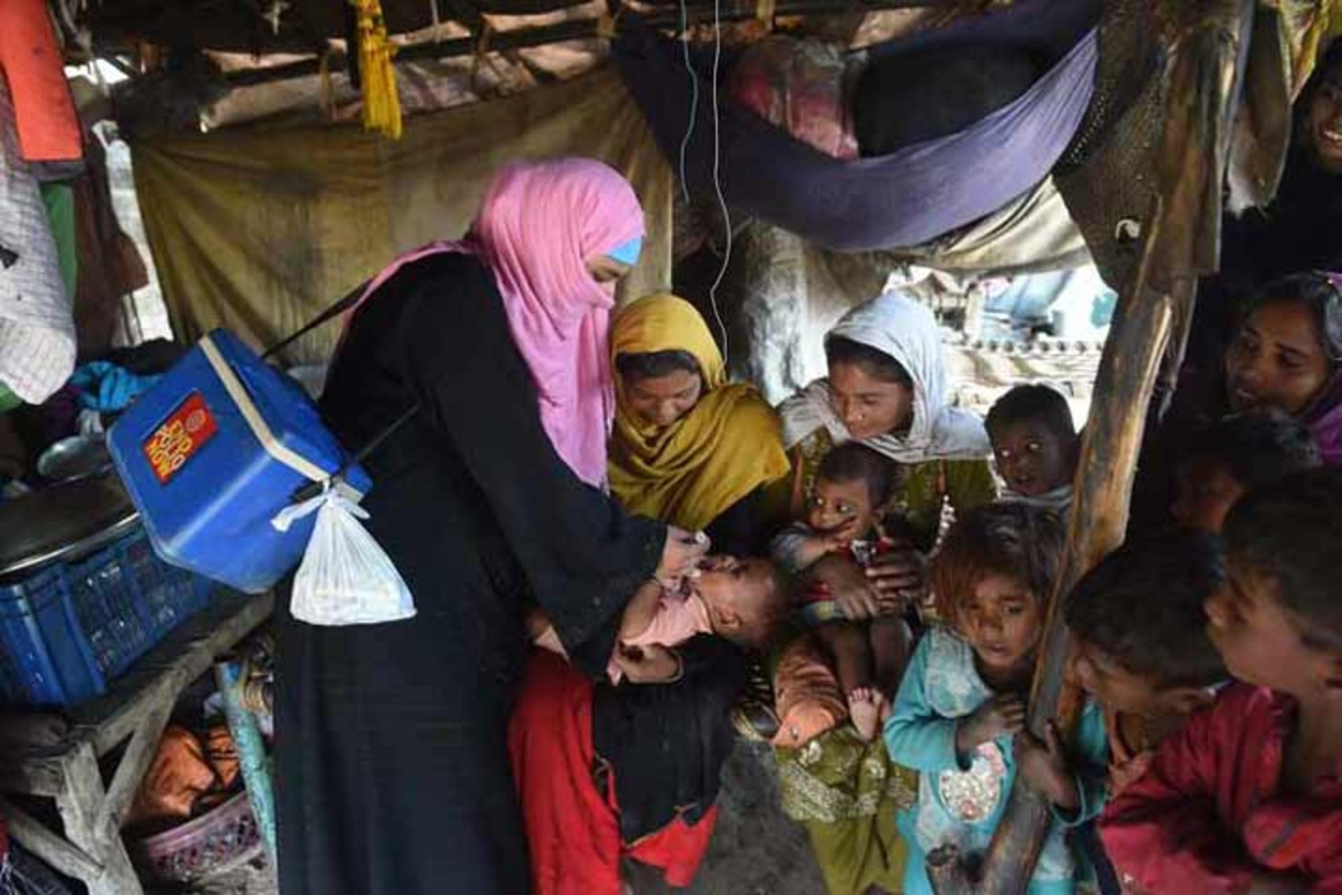 واکسیناتوری در لاهور، پاکستان در حال خوراندن قطره فلج اطفال 