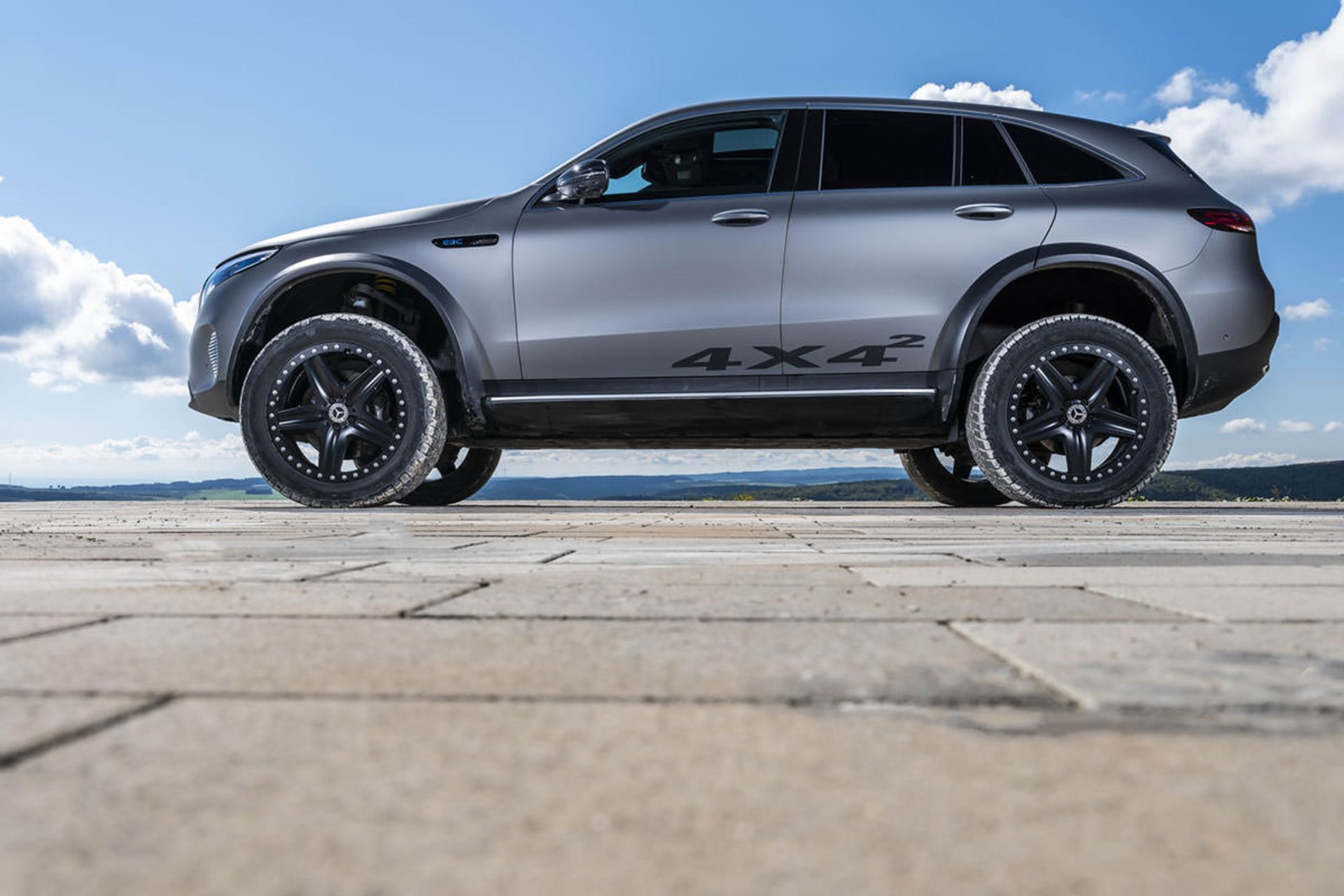 نمای جانبی خودروی مفهومی و شاسی بلند برقی مرسدس بنز / Mercedes-Benz EQC 4×4² نقره ای رنگ در مسیر آفرود