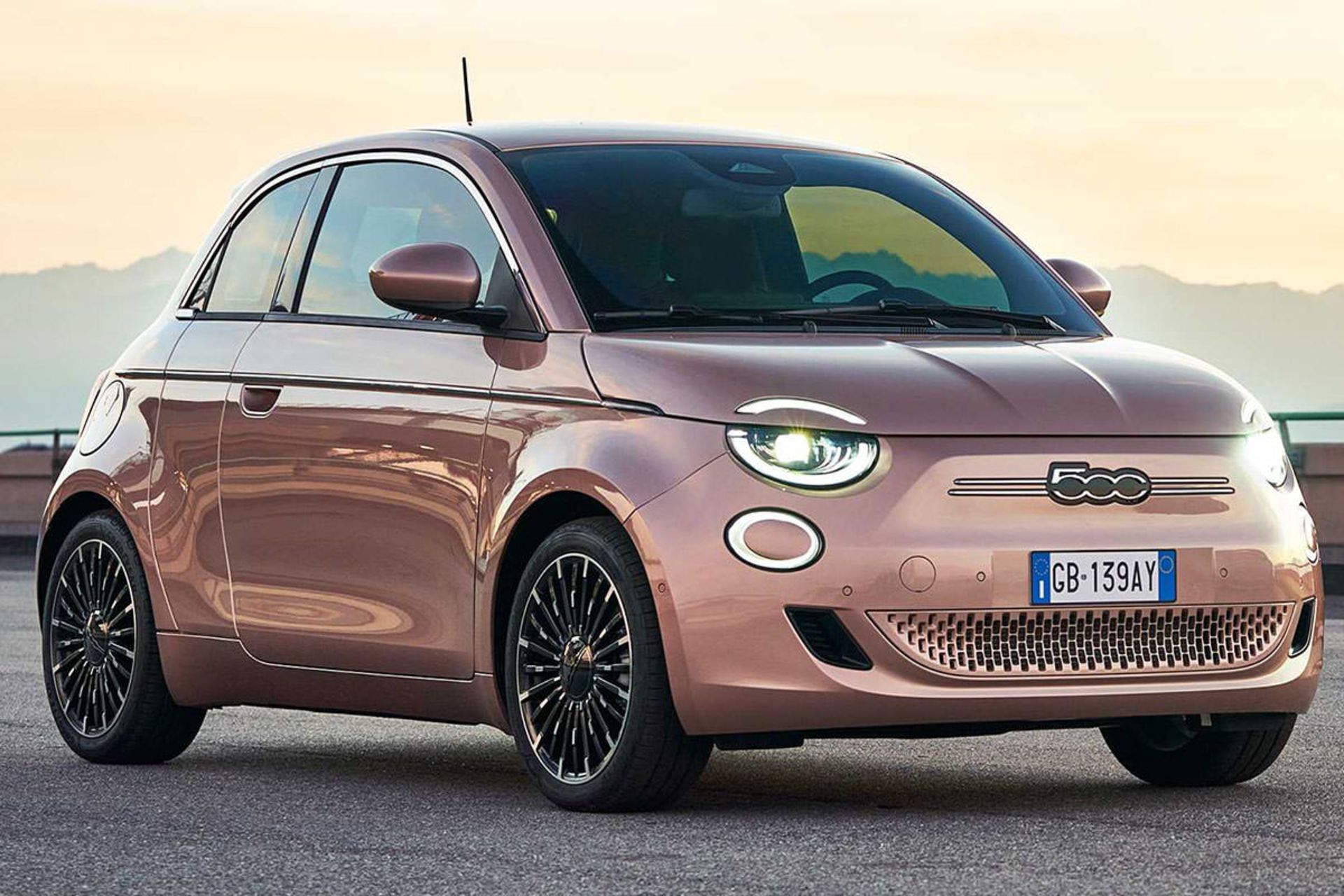 نمای سه چهارم خودروی برقی فیات 500 / Fiat 500 Electric با منظره آسمان