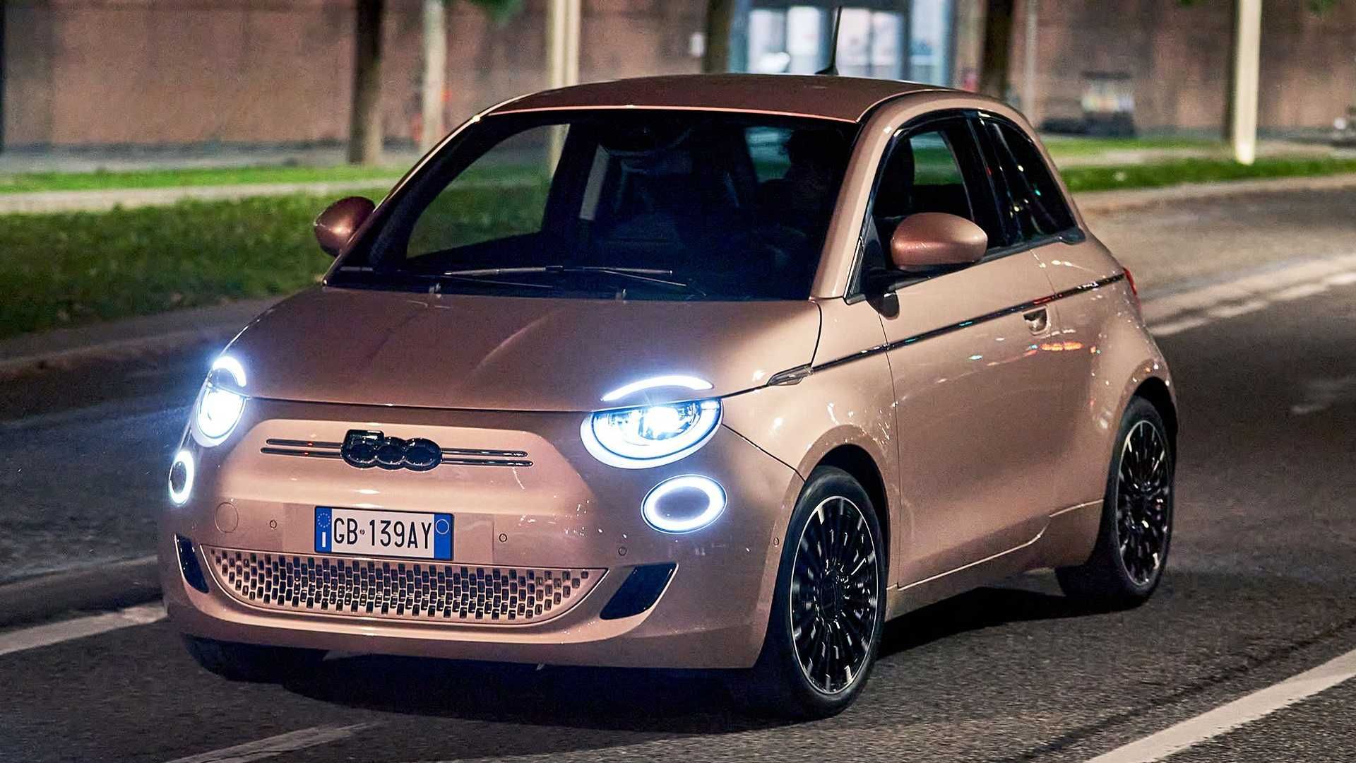 نمای سه چهارم خودروی الکتریکی فیات 500 / Fiat 500 Electric در خیابان با چراغ روشن