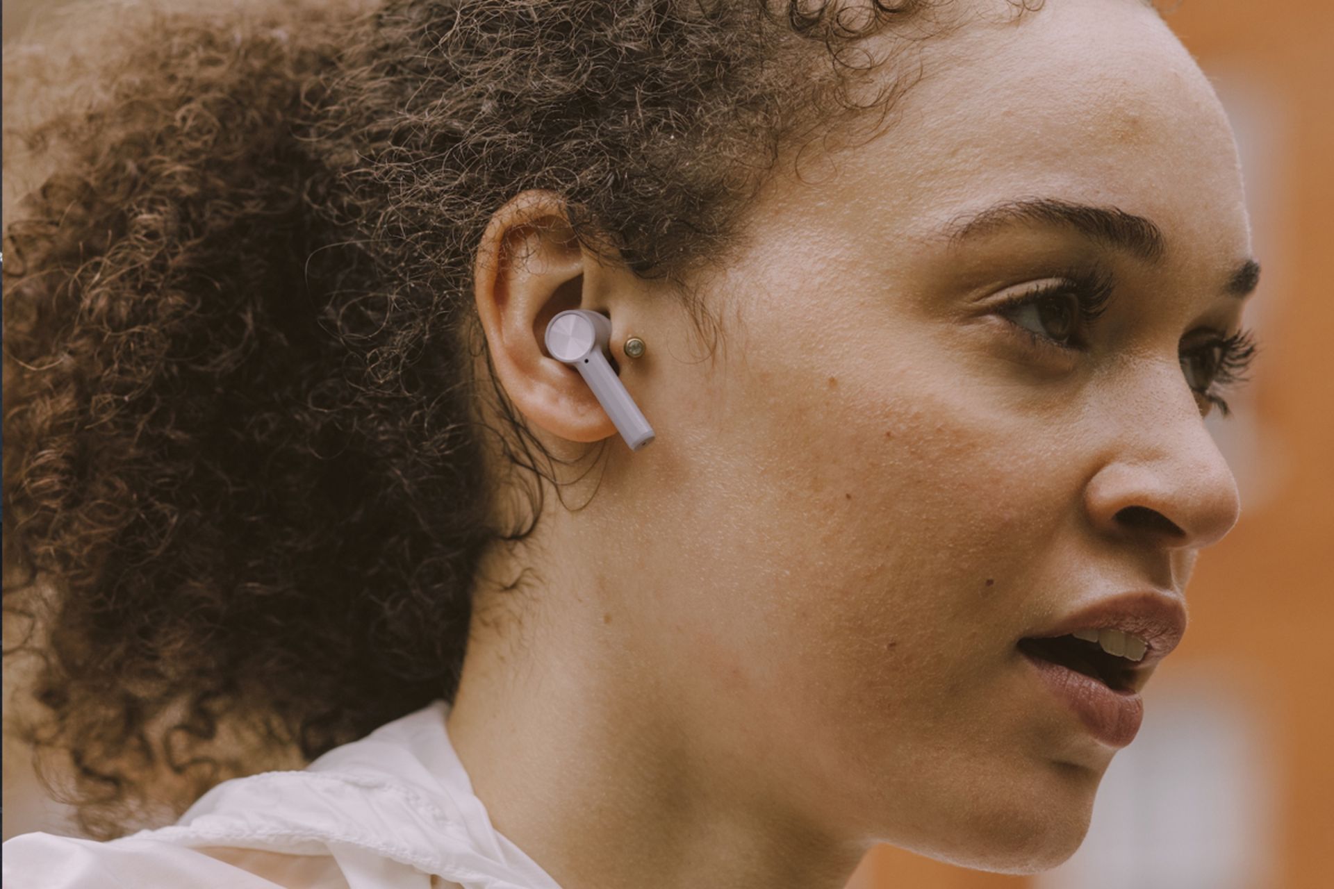 یک زن سیاه پوست با هدفون وان پلاس بادز زد / OnePlus Buds Z در گوش راست