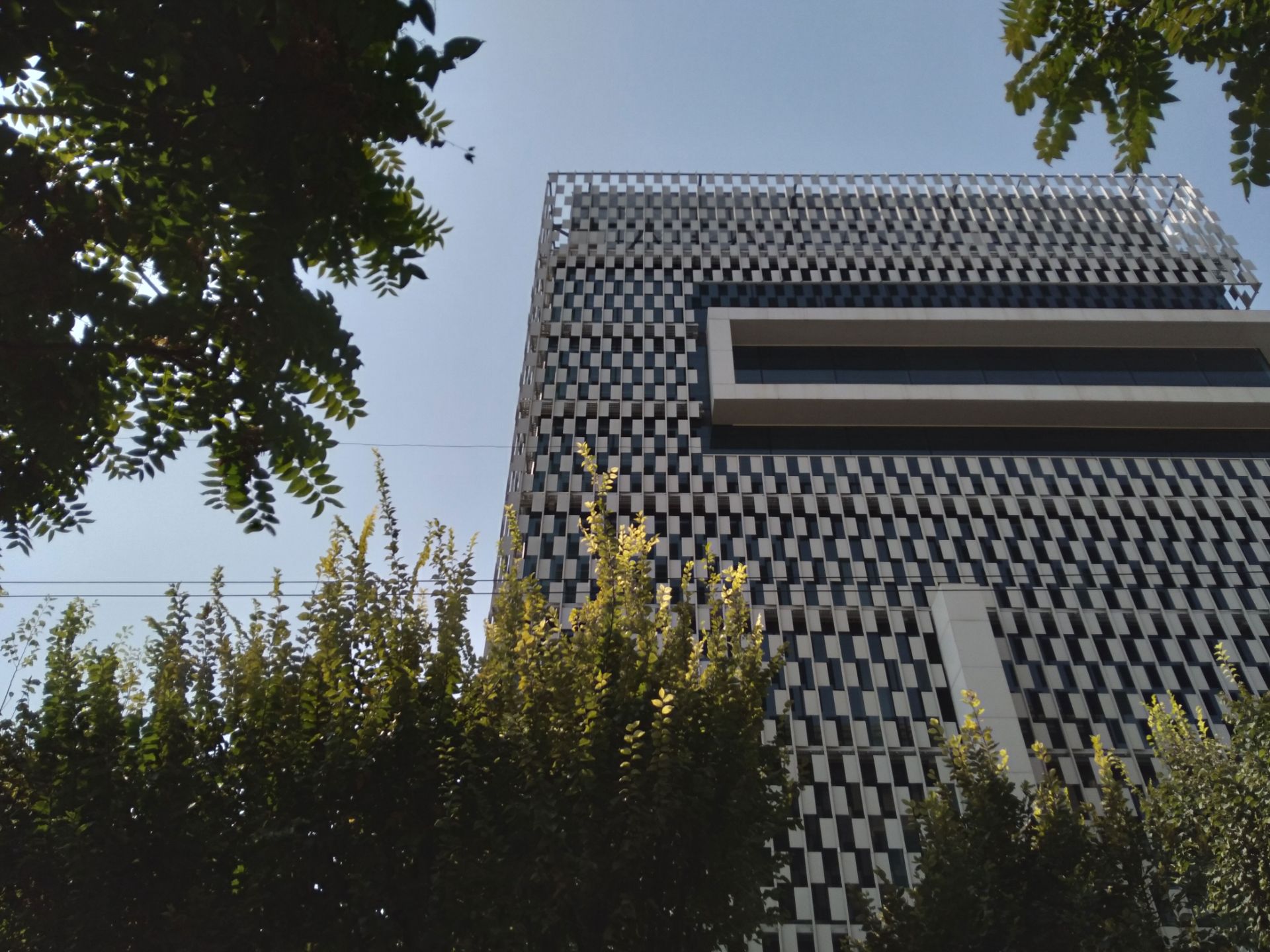 نمونه تصویر دوربین اصلی گلکسی A11 - نمای برج در روز از لابه‌لای درختان