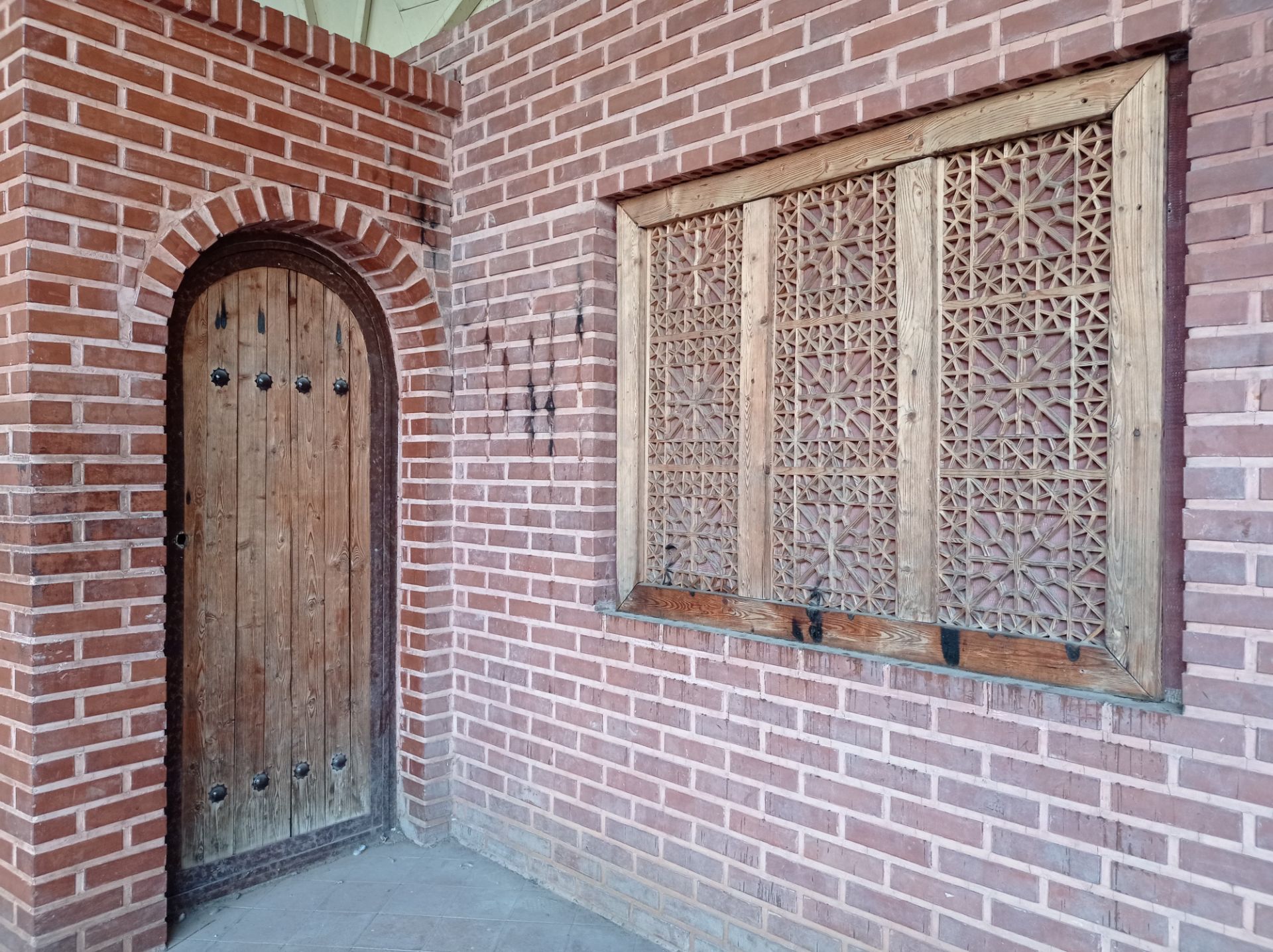 نمونه عکس 1x دوربین اصلی ردمی نوت ۹ در روشنایی - در و پنجره چوبی نمای آجر پارک صبا