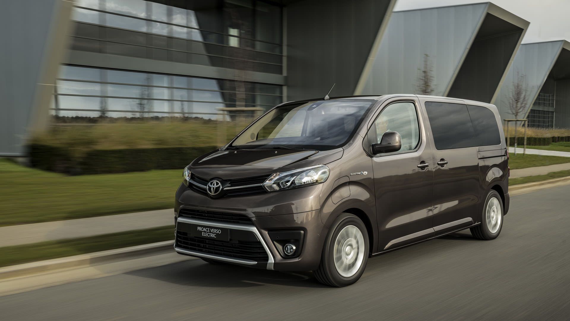 نمای سه چهارم ون الکتریکی تویوتا پروسه ورسو / 2021 Toyota Proace Verso در کنار ساختمان