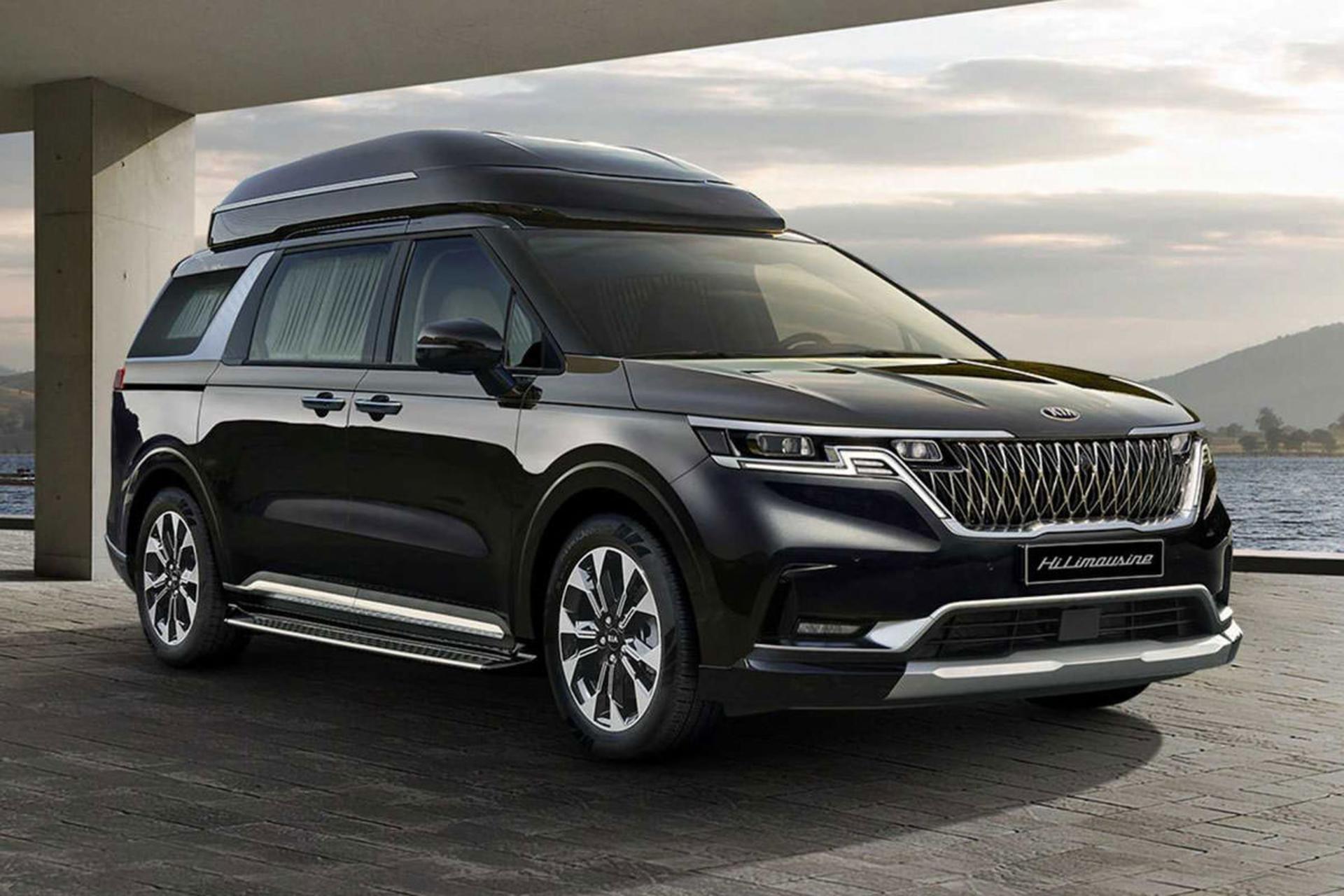 نمای جلو مینی ون کیا کارنیوال 2021 / 2021 Kia Carnival سیاه رنگ در کنار ساختمان