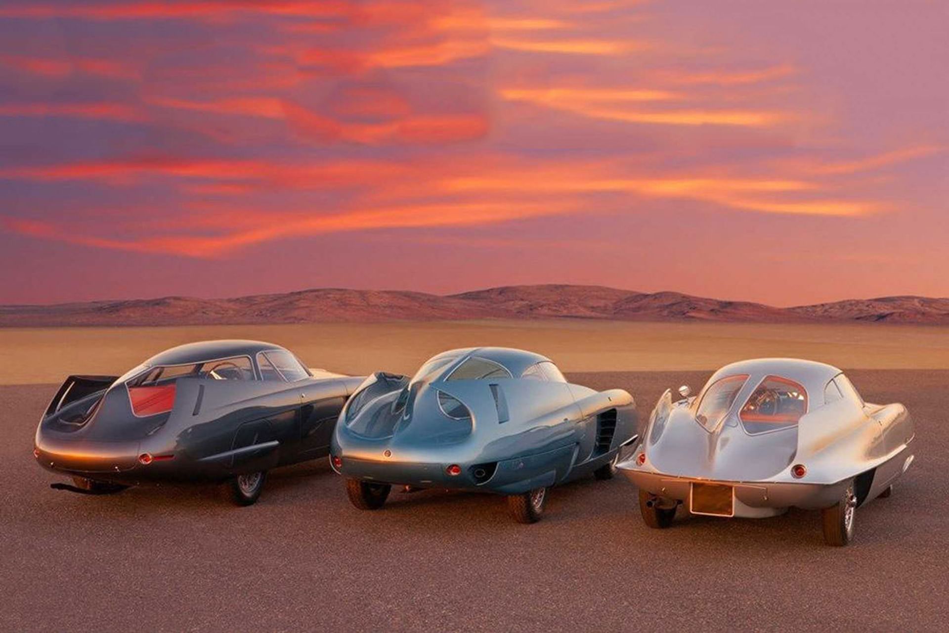 نمای عقب سه خودروی مفهومی آلفا رومئو / Alfa Romeo B.A.T. Concept Car با رنگ های آبی و سفید با منظره غروب آفتاب