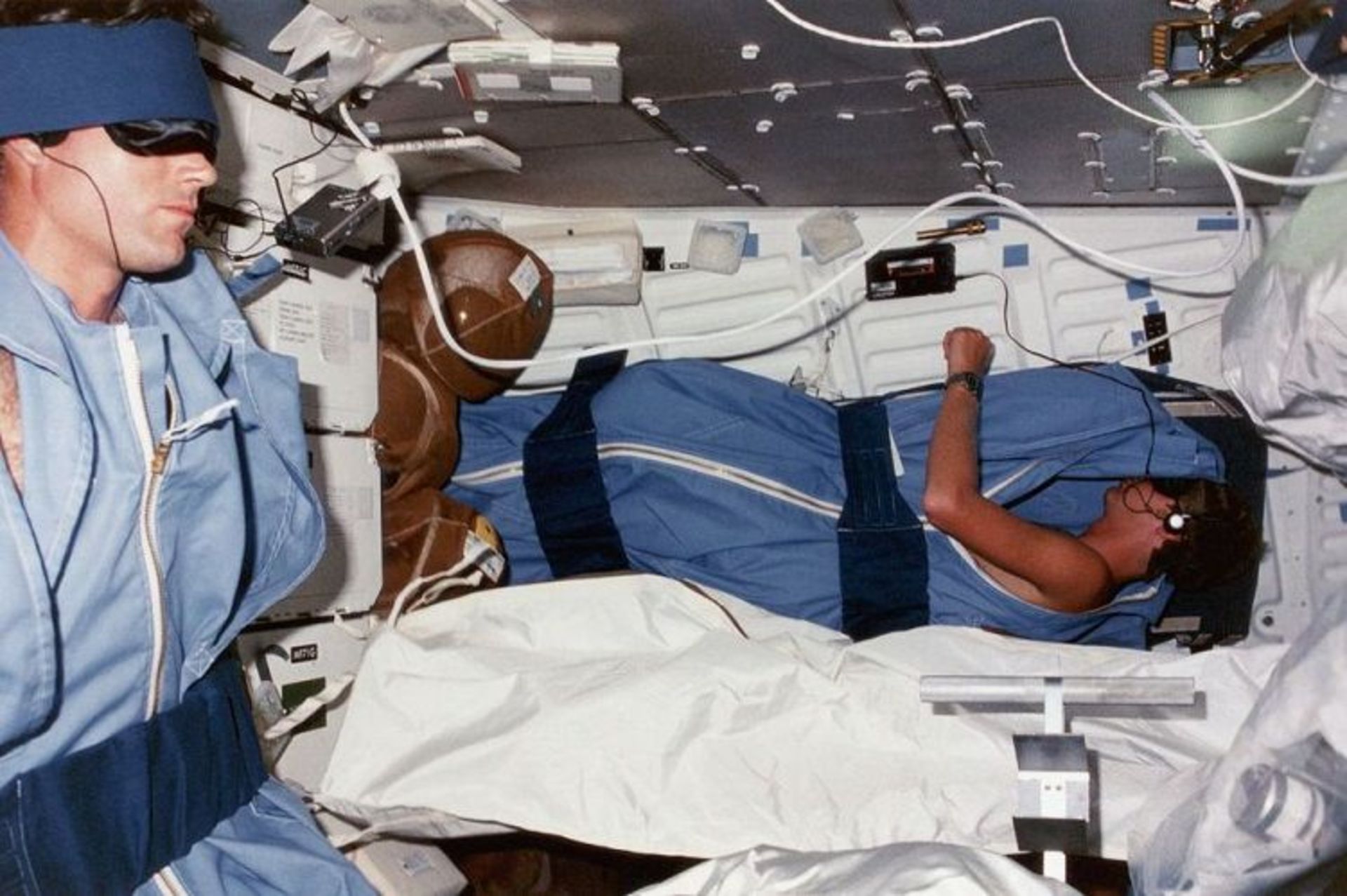 مرجع متخصصين ايران فضانوردان مايكل كتس و استيون هاولي در حال استفاده از واكمن براي خواب در سفينه فضايي ديسكاوري سال 1984