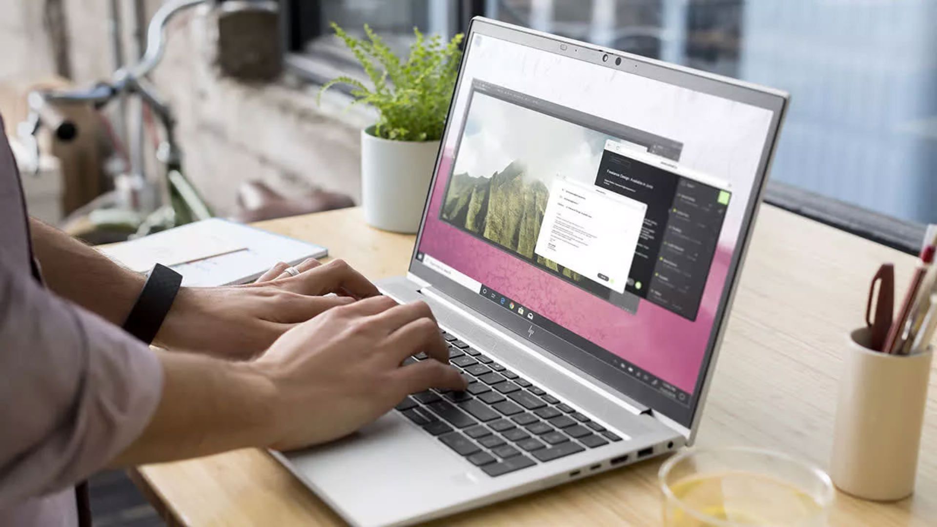 لپ تاپ اچ پی EliteBook 850 G8 روی میز با دست کاربر
