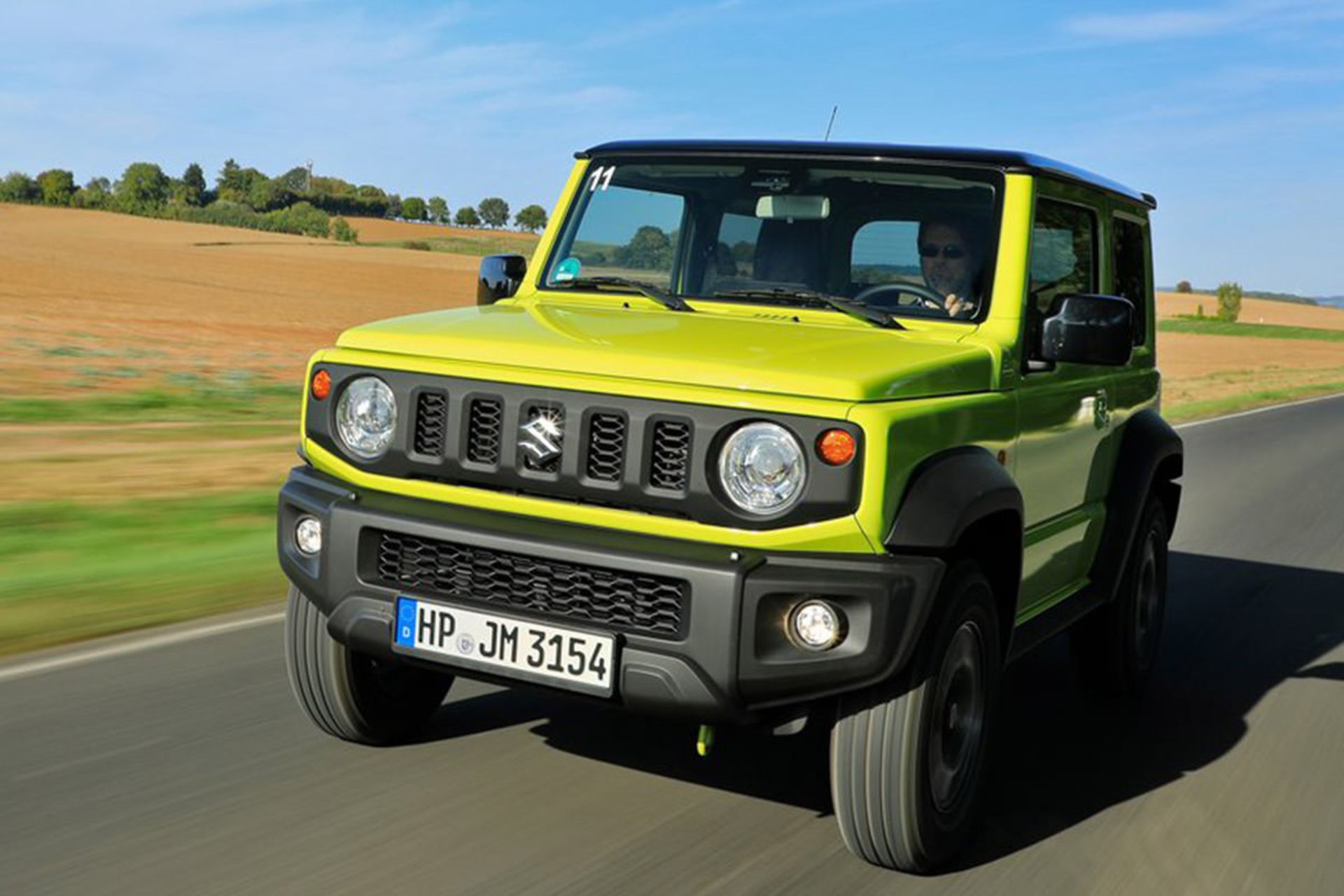 نمای جلو سوزوکی جیمنی شاسی بلند کوچک 4x4 در جاده صاف آسمان آبی