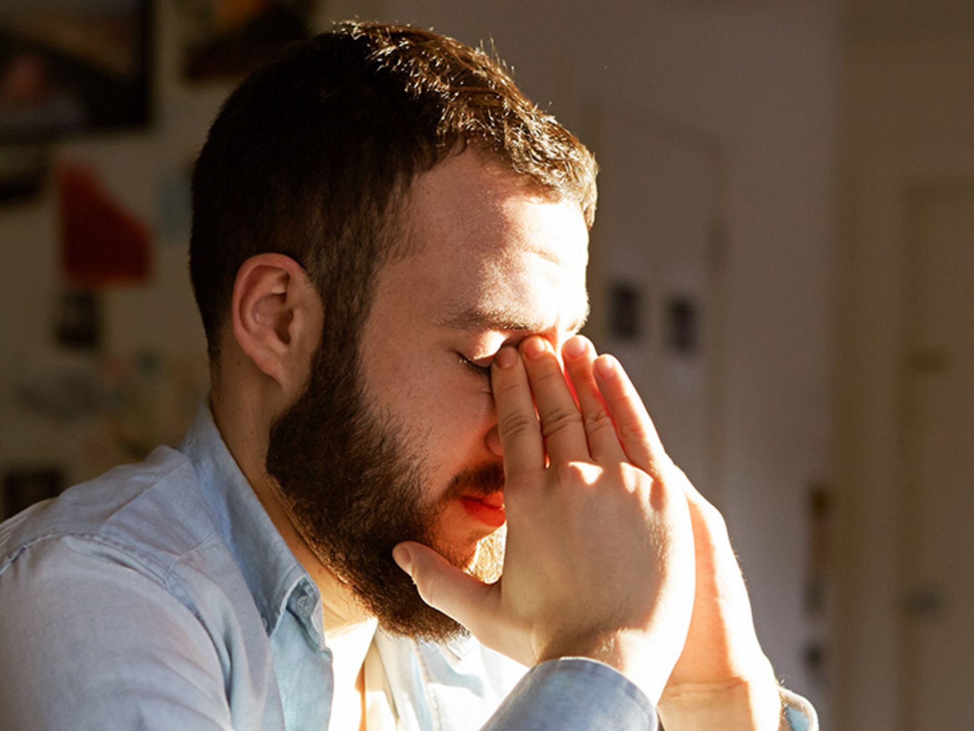 فردی که به دلیل آب مروارید دستش را بر روی چشمانش گذاشته است
