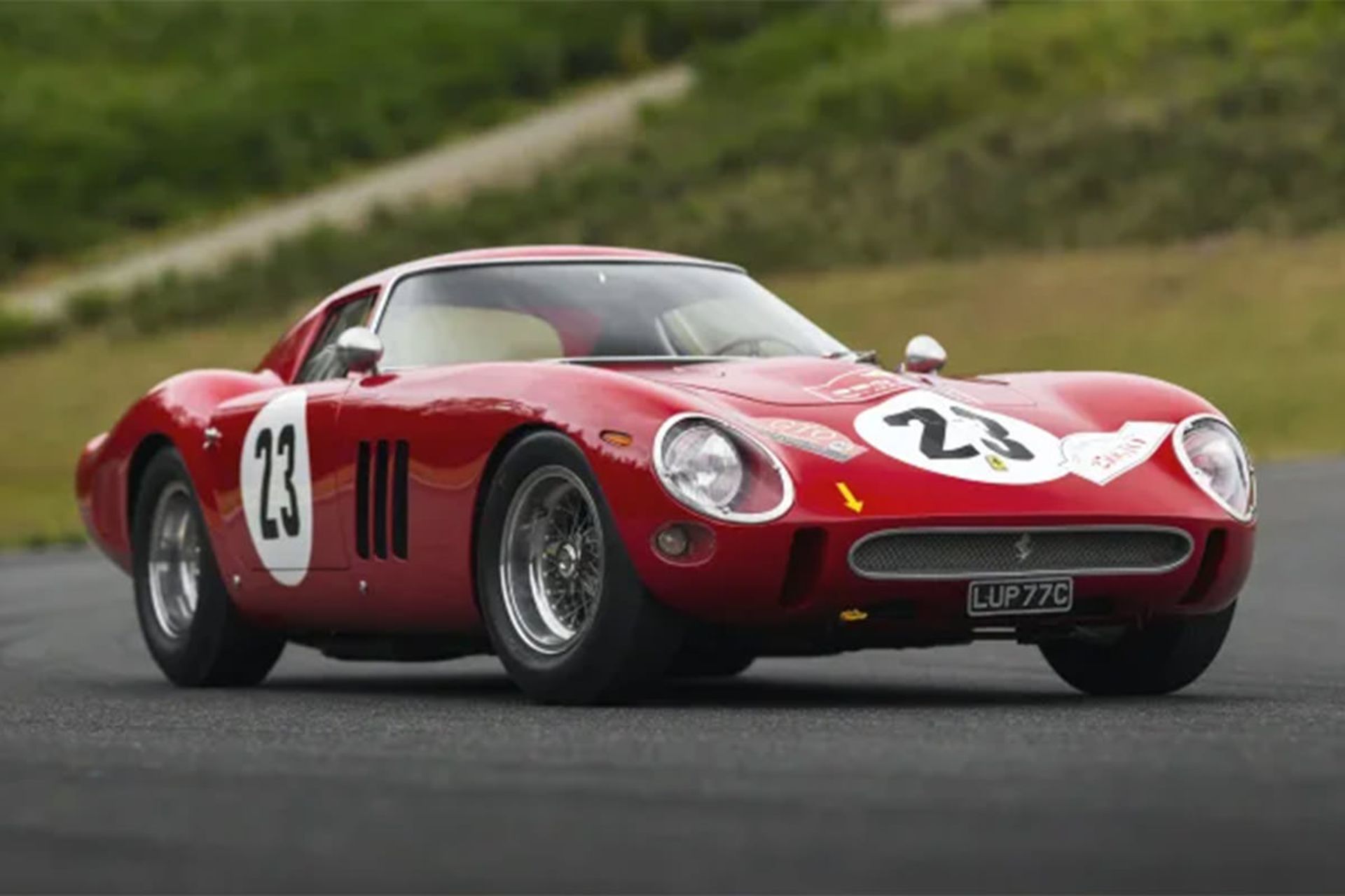 نمای خودرو کلاسیک و اسپرت فراری / Ferrari 250 GTO قرمز رنگ در جاده آسفالت با زمینه علف سبز