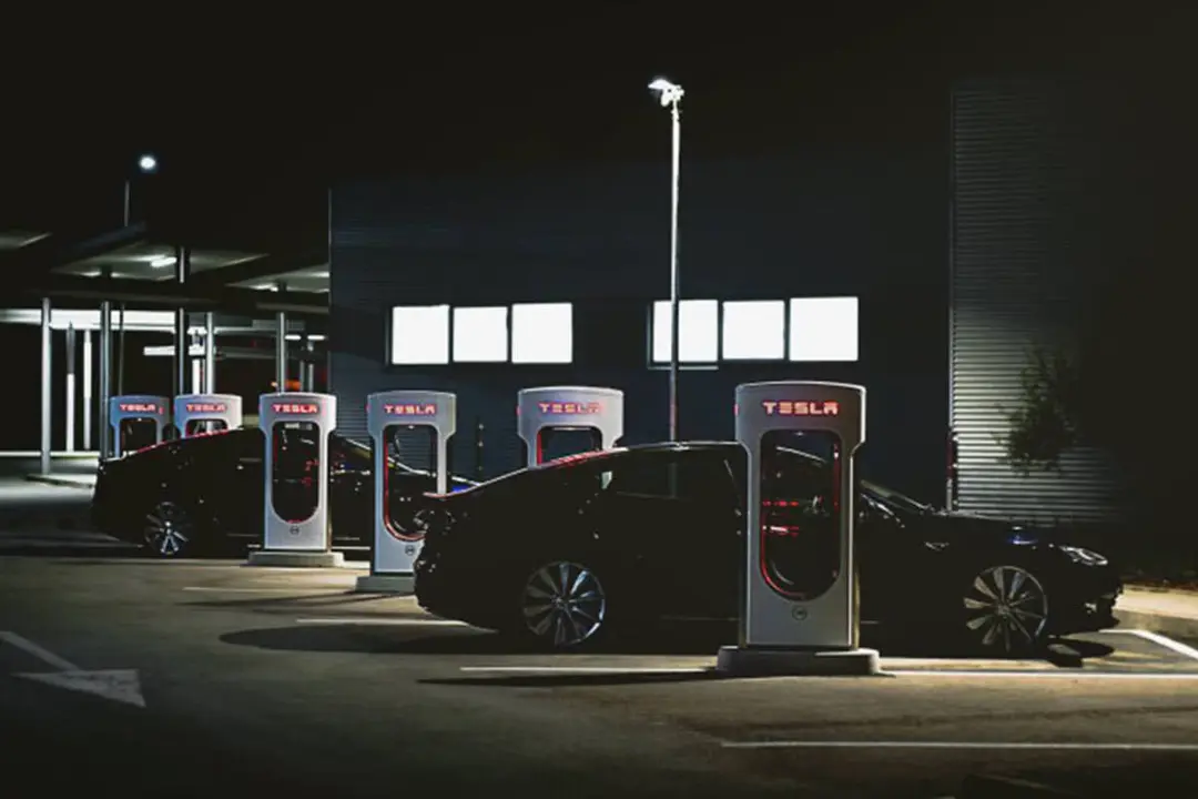 خودروی الکتریکی / electric car تسلا / tesla در کنار شارژر / car charger در شب