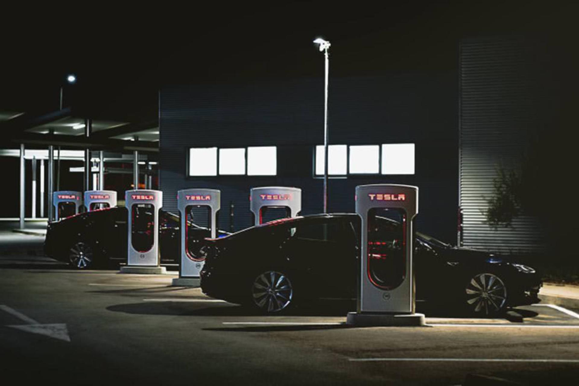 خودروی الکتریکی / electric car تسلا / tesla در کنار شارژر / car charger در شب