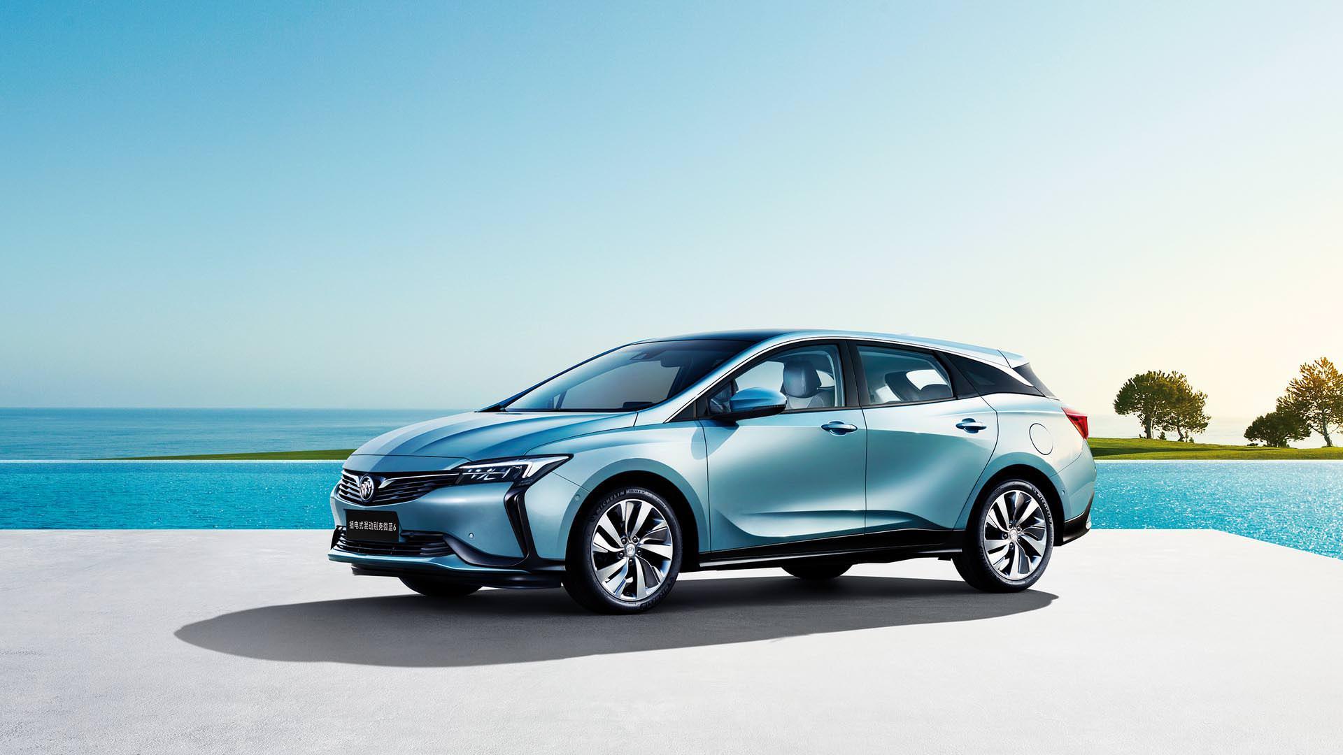 خودروی پلاگین هیبریدی / hybrid car بیوک ویلایت 6 / buick velite 6 آبی رنگ با زمینه دریا و درخت