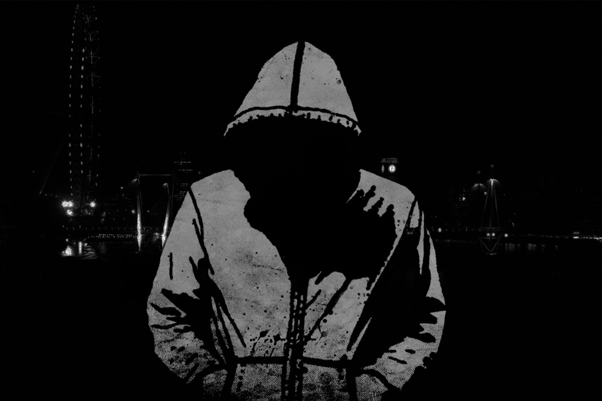 هکر ناشناس با هودی درحالت ایستاده سر به پایین دست در جیب