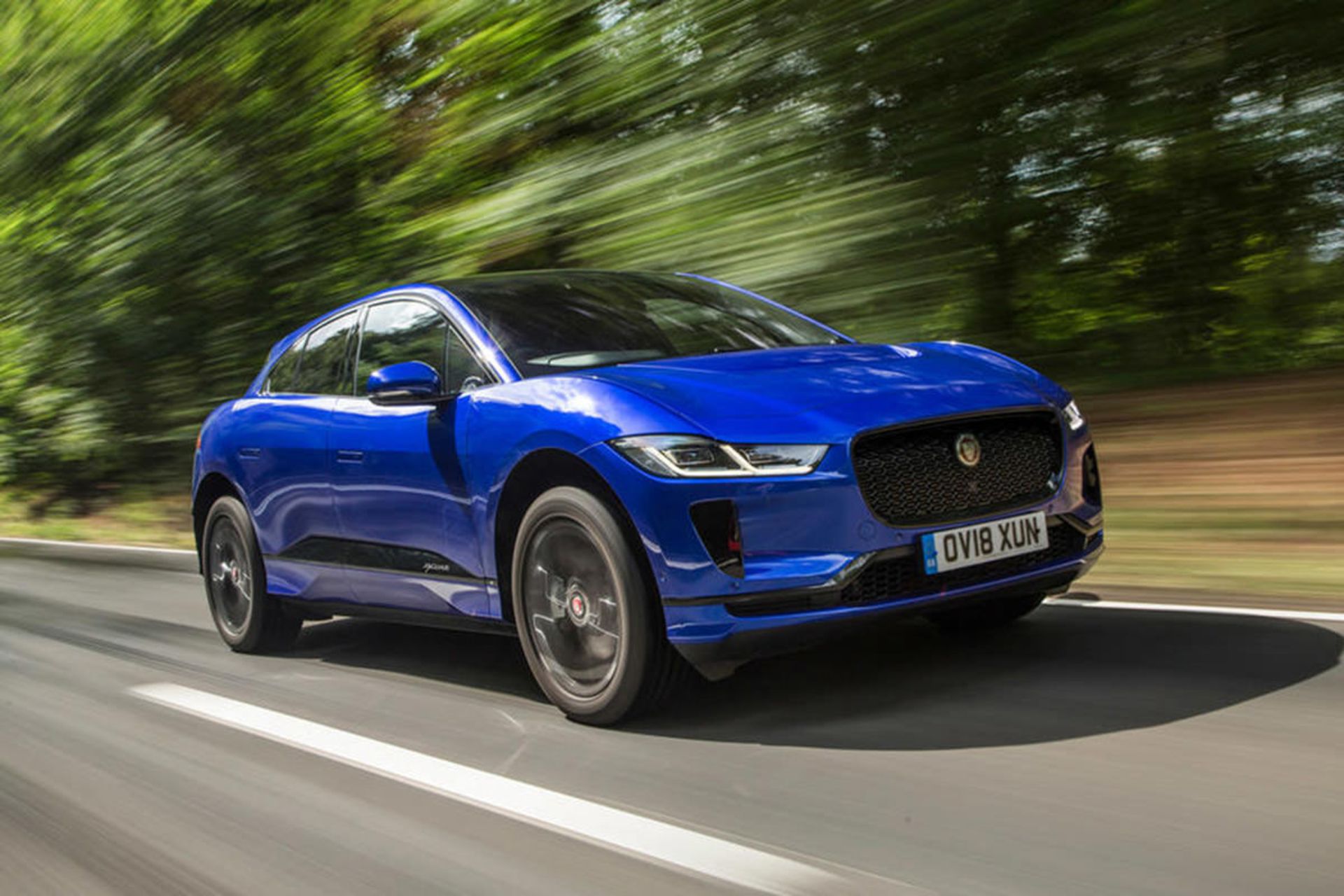 خودروی جگوار آی پیس / jaguar i-pace آبی رنگ در جاده جنگلی