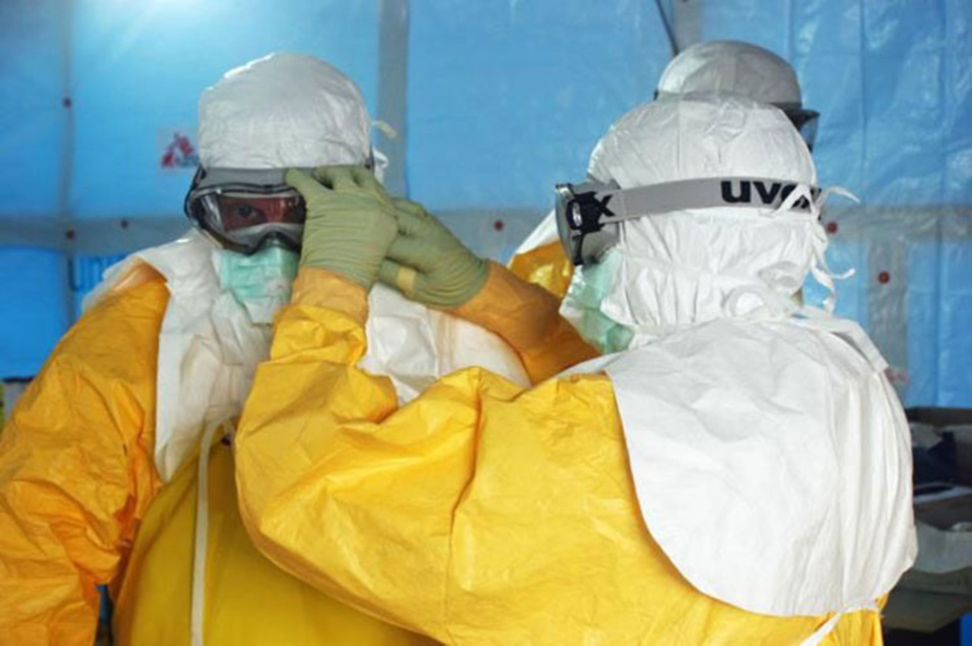 Health care workers put on protective gear before entering an Ebola treatment unit in Liberia