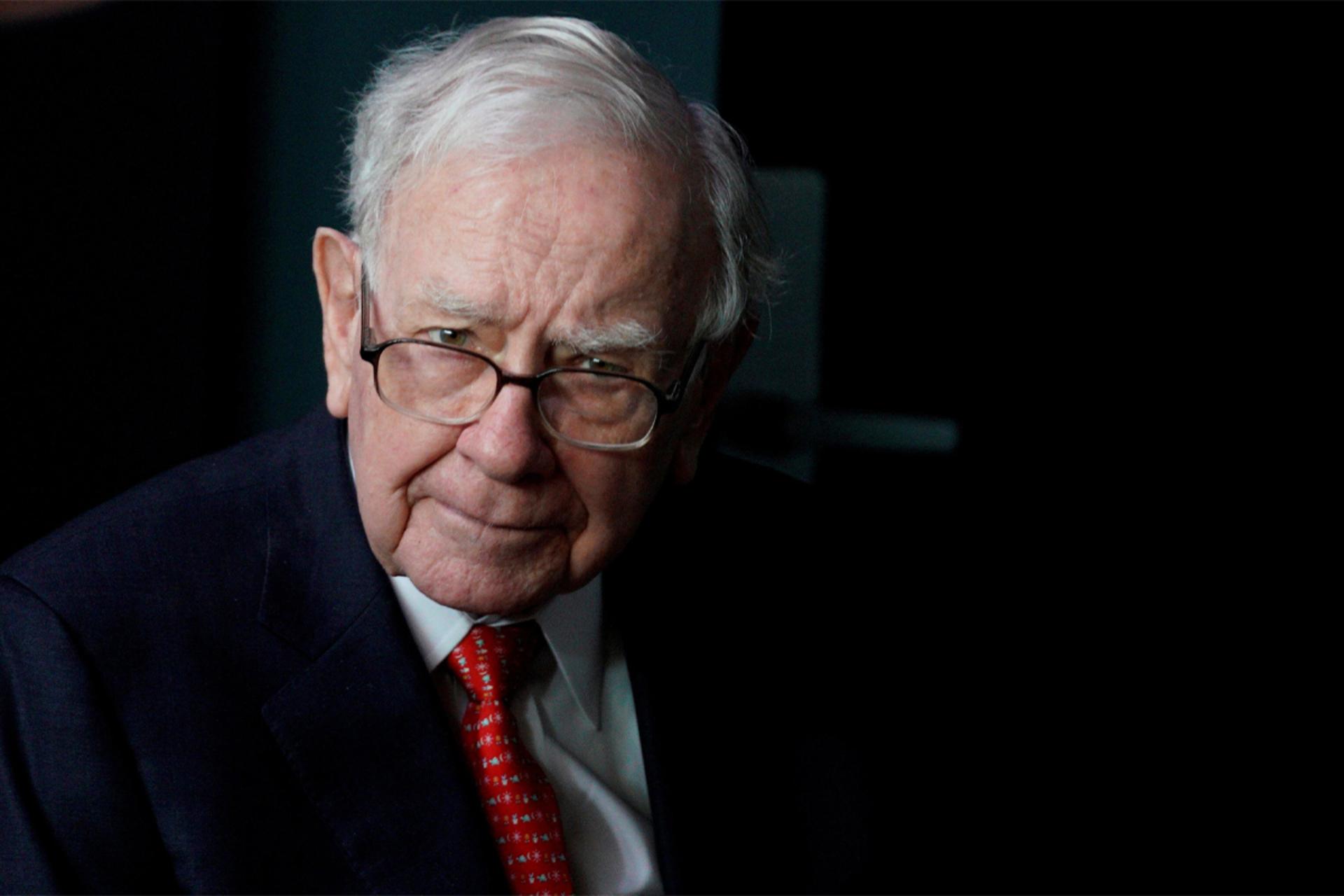 وارن بافت / Warren Buffett با کت و شلوار و عینک متفکر درحال نگاه به دوربین
