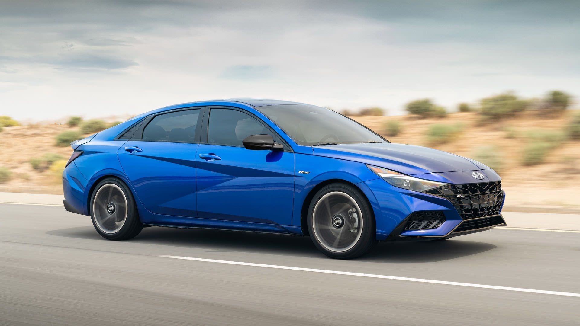 نمای جانبی هیوندای النترا ان لاین / 2021 Hyundai Elantra N Line آبی رنگ در جاده با آسمان آبی