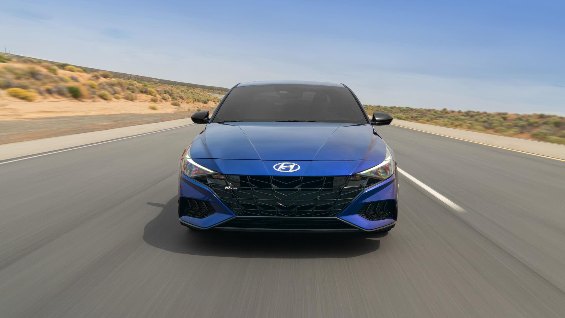 نمای جلو سدان هیوندای النترا ان لاین / 2021 Hyundai Elantra N Line آبی رنگ در جاده با آسمان آبی