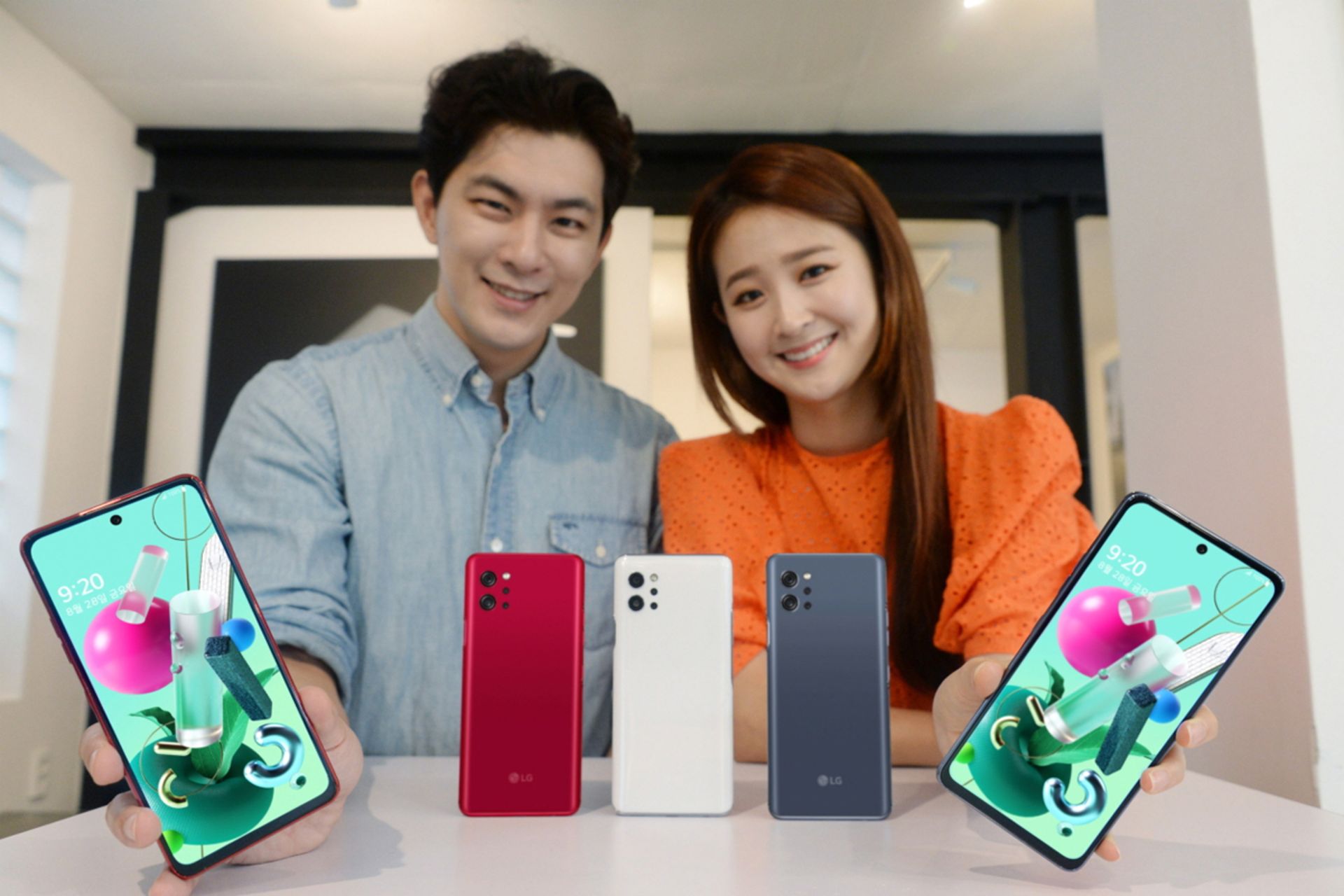 مرد و زن کره ای در حال لبخند با ال جی کیو 92 فایوجی / LG Q92 5G در دست