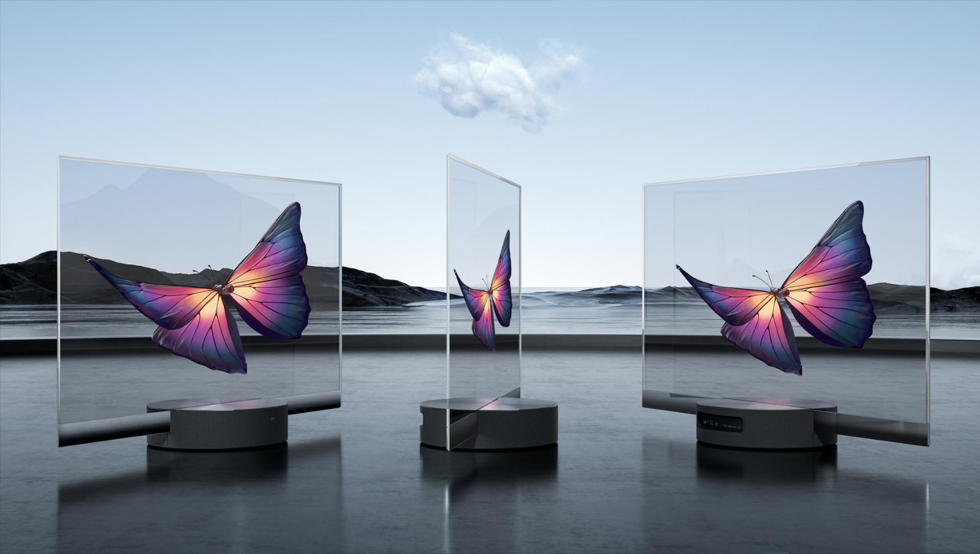 سه دستگاه شیائومی Mi TV Lux OLED Transparent Edition از جلو و نیم رخ در فضای باز آسمان آبی