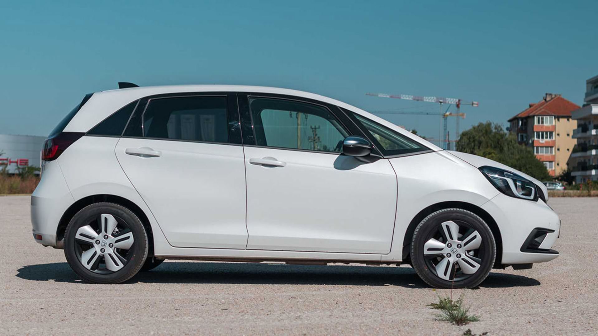 نمای جانبی خودروی هیبریدی / Hybrid car هوندا جاز فیت / 2020 Honda Jazz (Fit) e:HEV سفید رنگ با منظره آسمان آبی