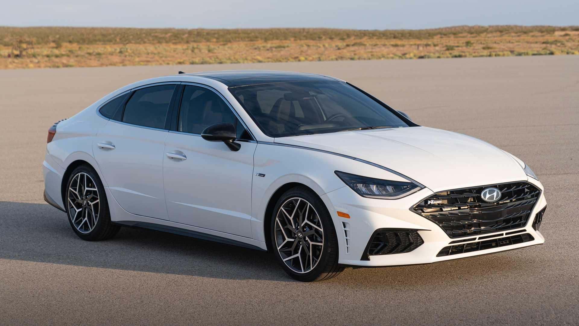 نمای سه چهارم چپ سدان اسپرت هیوندای سوناتا ان لاین / 2021 Hyundai Sonata N Line سفید رنگ با نمای آسمان ابری