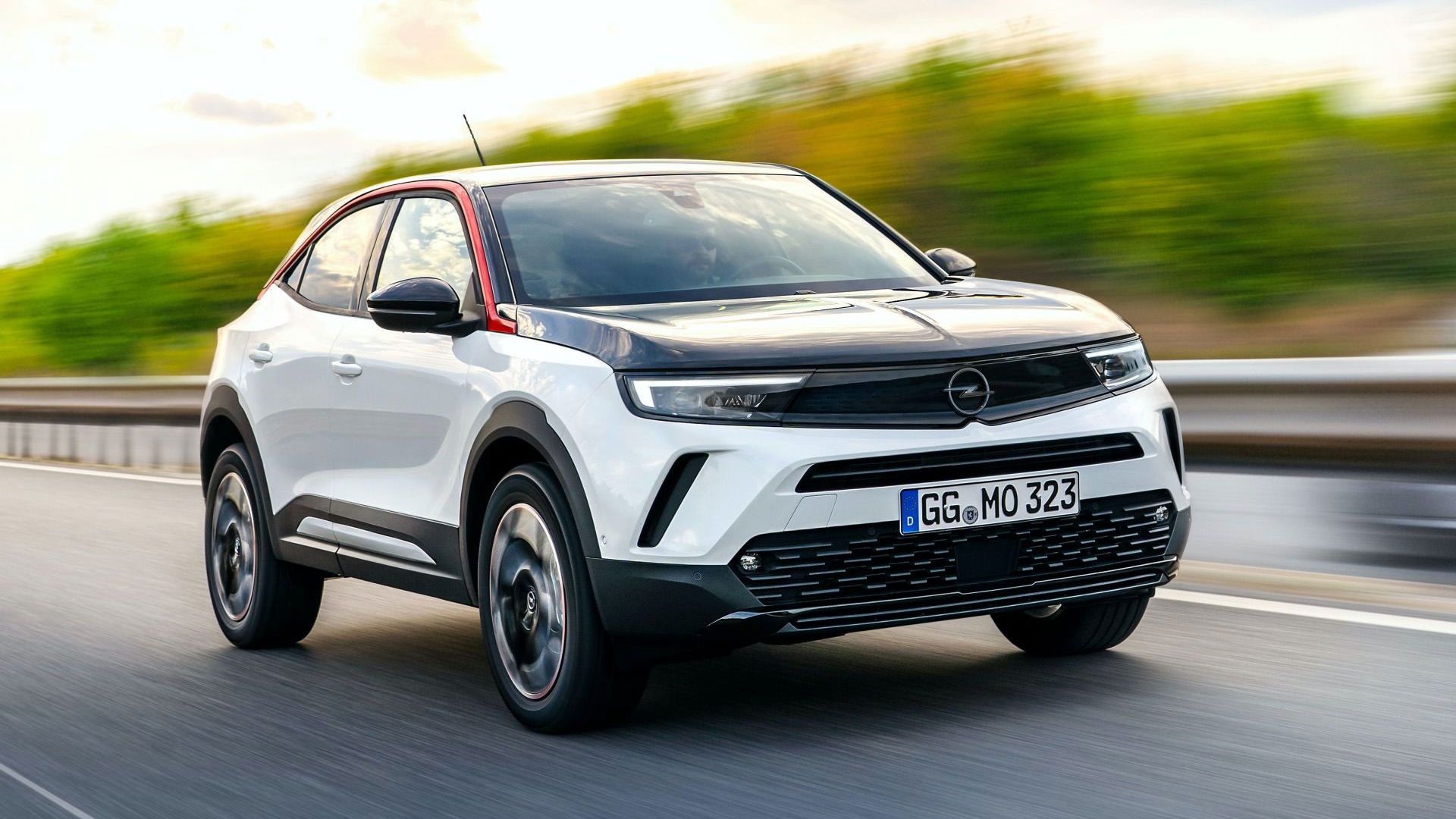 نمای جلو چپ کراس اور کامپکت اوپل موکا 2021 / Opel Mokka با طرح دو رنگ سفید و مشکی در جاده با منظره آسمان آبی