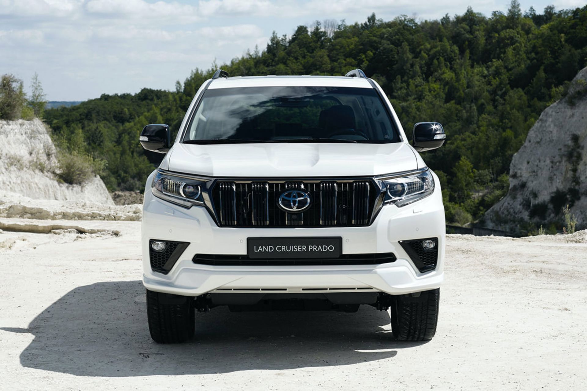 نمای جلو خودرو شاسی بلند تویوتا لندکروزر پرادو 2021 / 2021 Toyota Land Cruiser Prado سفید رنگ در کوهستان و منظره درخت