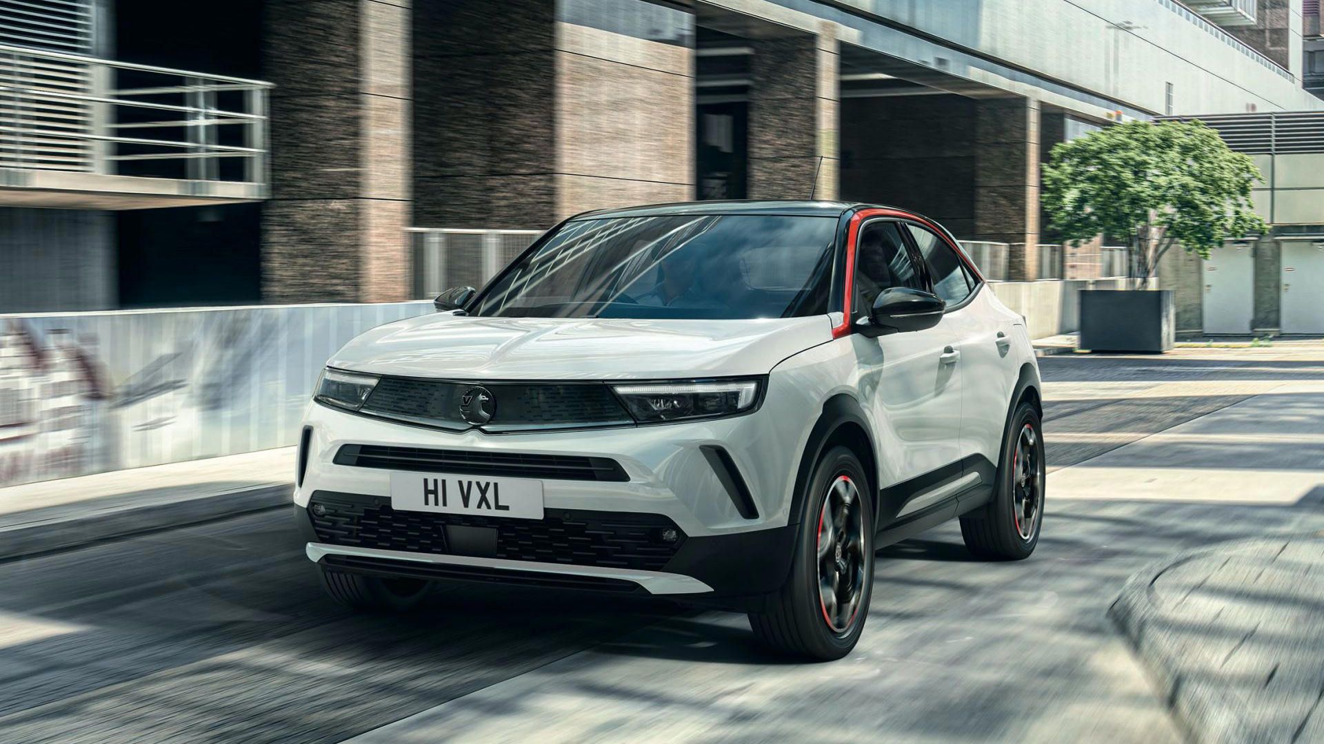 نمای سه چهارم کراس اور کامپکت اوپل موکا 2021 / Opel Mokka با طرح دو رنگ سفید و مشکی در خیابان