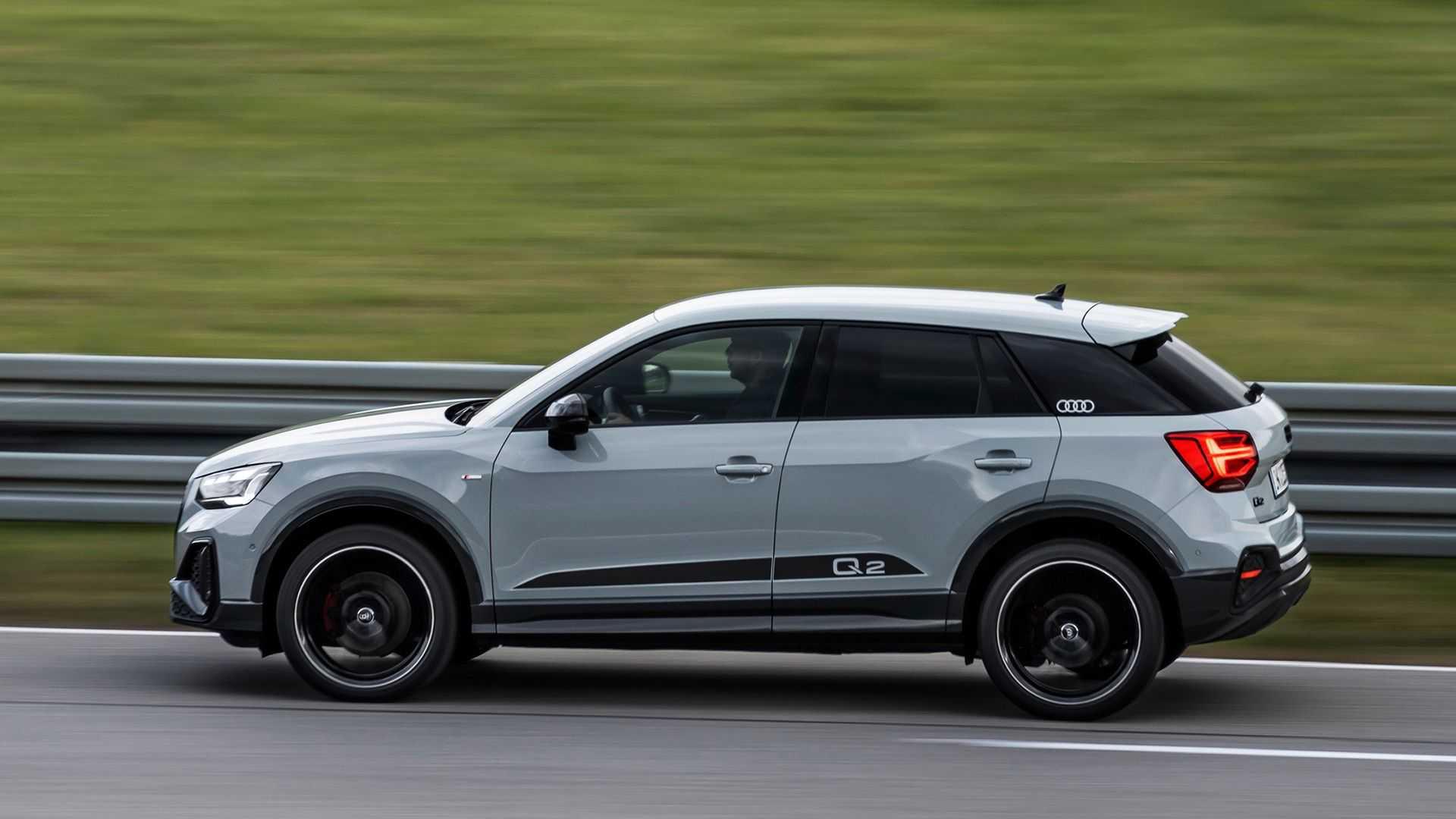 نمای جانبی کراس اور آئودی کیو 2 / 2021 Audi Q2 crossover با رنگ خاکستری در جاده و منظره سبز