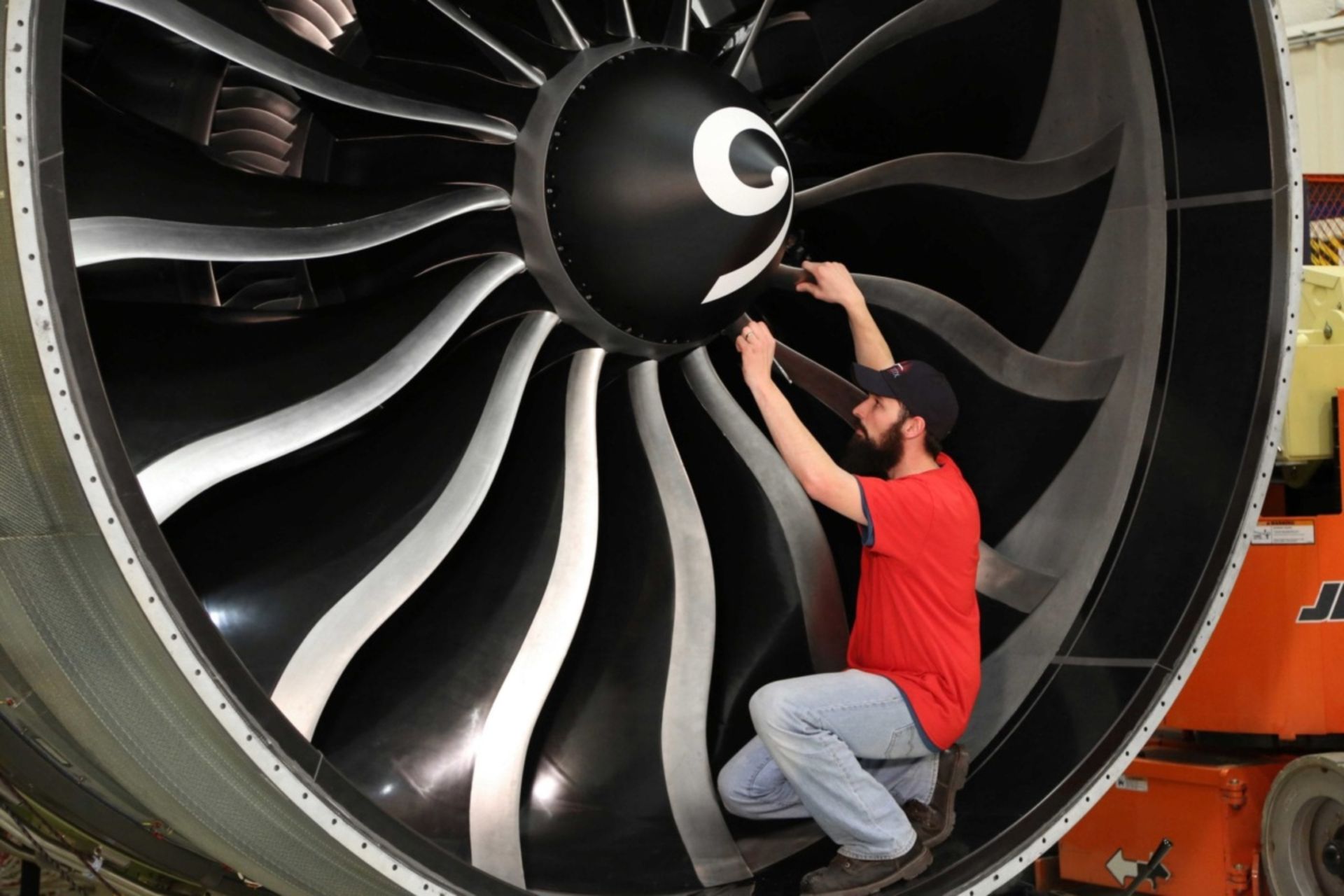 مرد با لباس قرمز در کنار موتور جت GE9x جنرال الکتریک