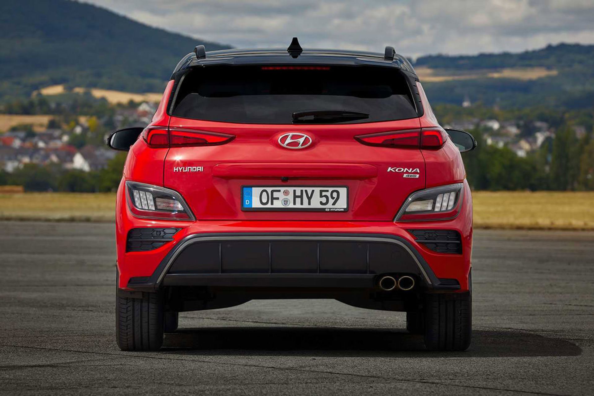 نمای عقب کراس اور هیوندای کنا ان لاین / Hyundai Kona N-Line crossover قرمز رنگ با زمینه آسمان ابری