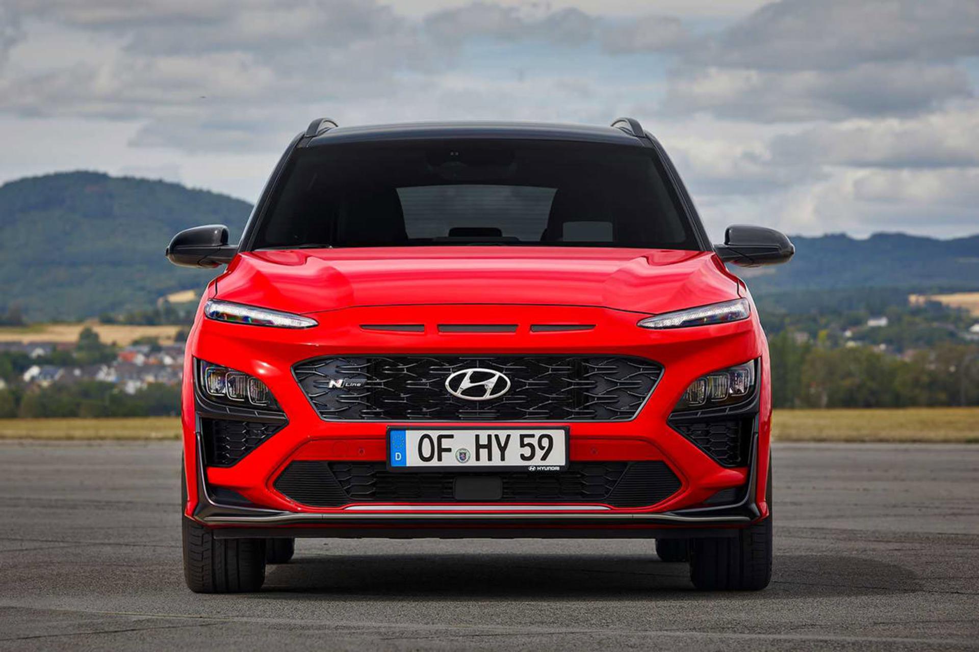 نمای جلو کراس اور هیوندای کنا ان لاین / Hyundai Kona N-Line crossover قرمز رنگ با زمینه آسمان ابری