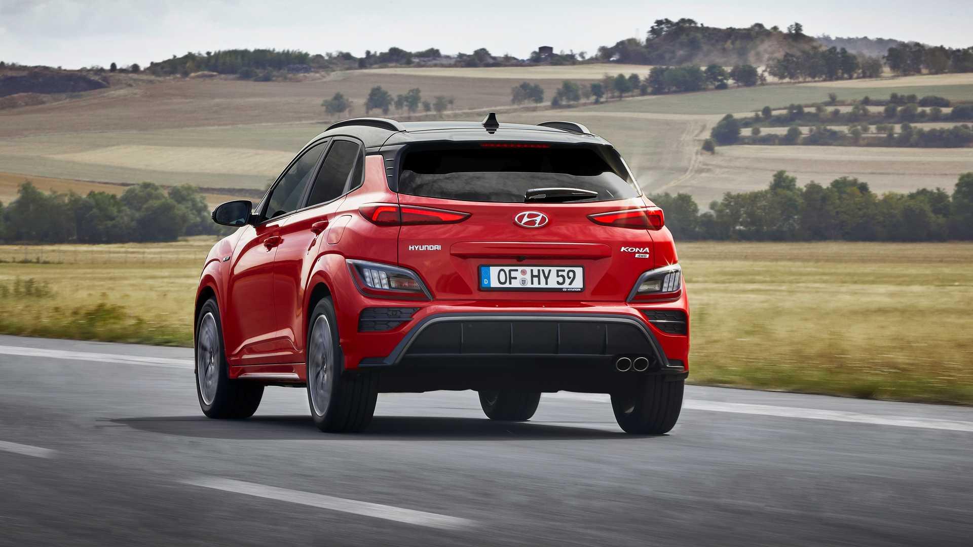 نمای عقب کراس اور هیوندای کنا ان لاین / Hyundai Kona N-Line crossover قرمز رنگ در جاده با زمینه آسمان آبی