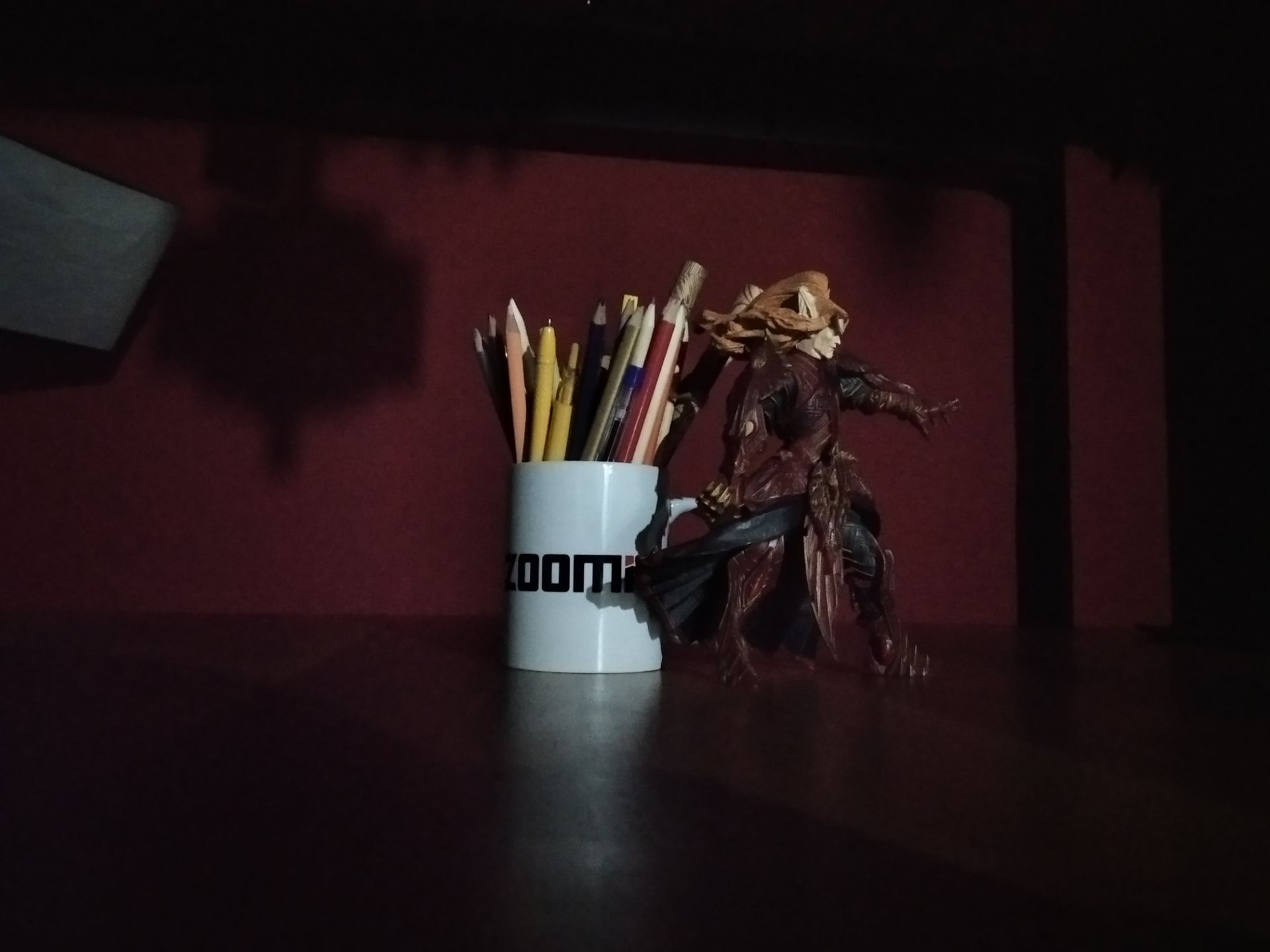 نمونه عکس ثبت شده توسط دوربین اصلی شیائومی ردمی ۸ در محیط کم‌نور - لیوان زومیت و اکشن فیگور