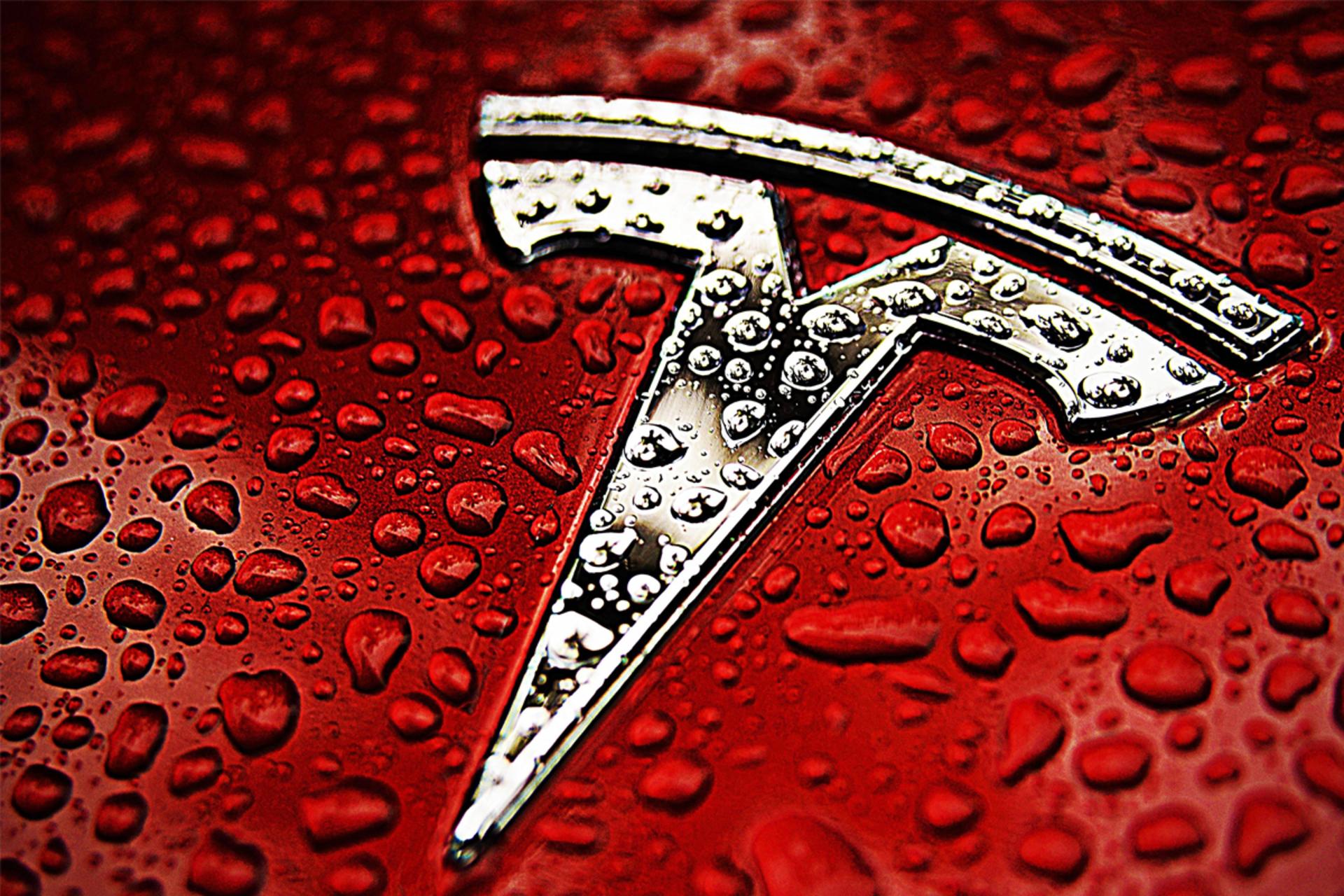 لوگو تسلا / Tesla روی خودرو قرمز از نمای نزدیک