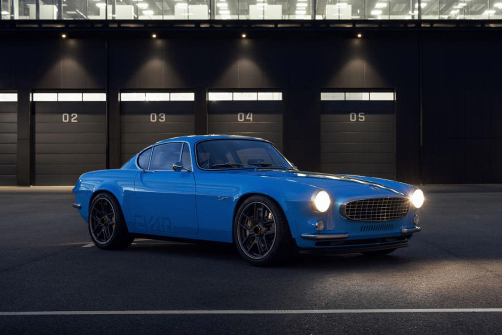 نمای جلو خودرو بازسازی شده ولوو پی 1800 / Volvo P1800 شرکت سایان / Cyan آبی رنگ در پارکینگ