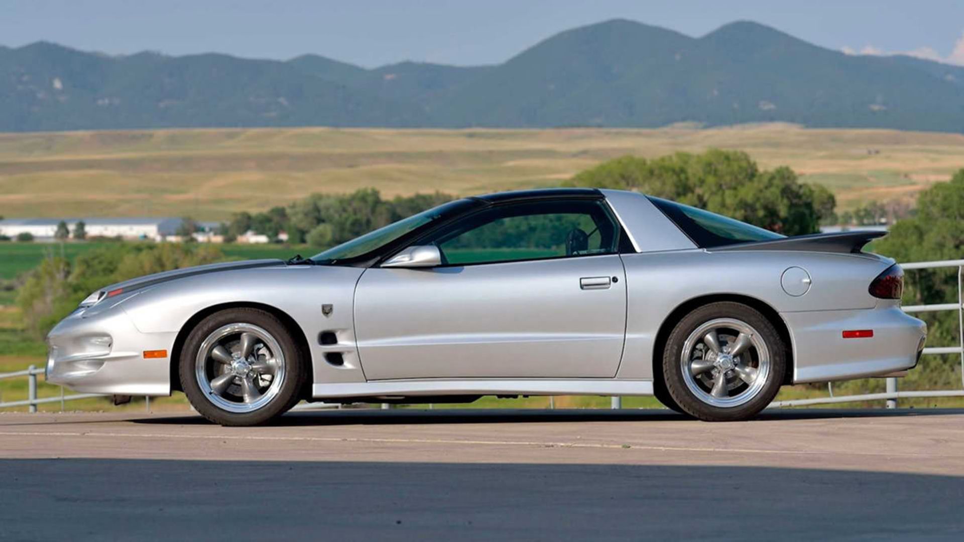 نمای جانبی خودرو عضلانی پونتیاک ترنس ام بلک برد / Pontiac Trans Am مدل 2002 نقره ای رنگ