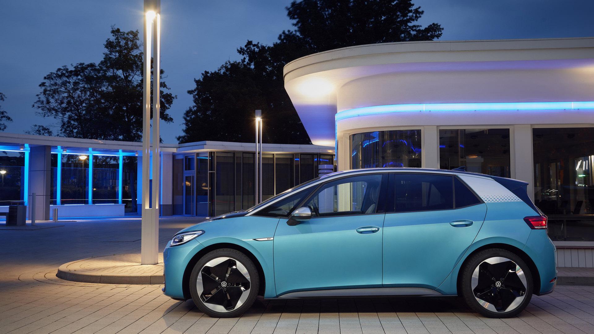 نمای جانبی هاچ بک برقی فولکس‌واگن ID.3 / Volkswagen ID.3 Electric Hatchback آبی رنگ در کنار ساختمان