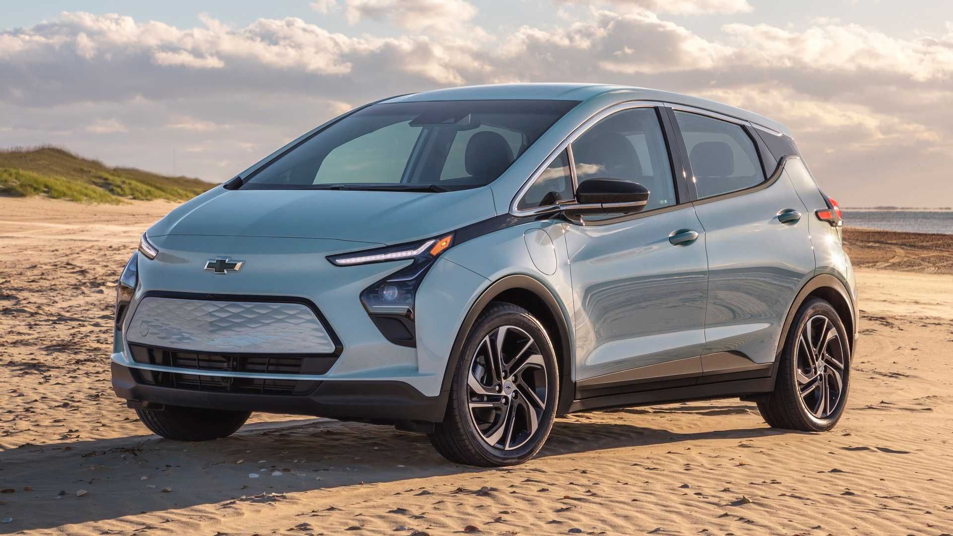 نمای سه چهارم جلو کراس اور برقی شورولت بولت ای وی / Chevrolet Bolt EV crossover با منظره آسمان ابری
