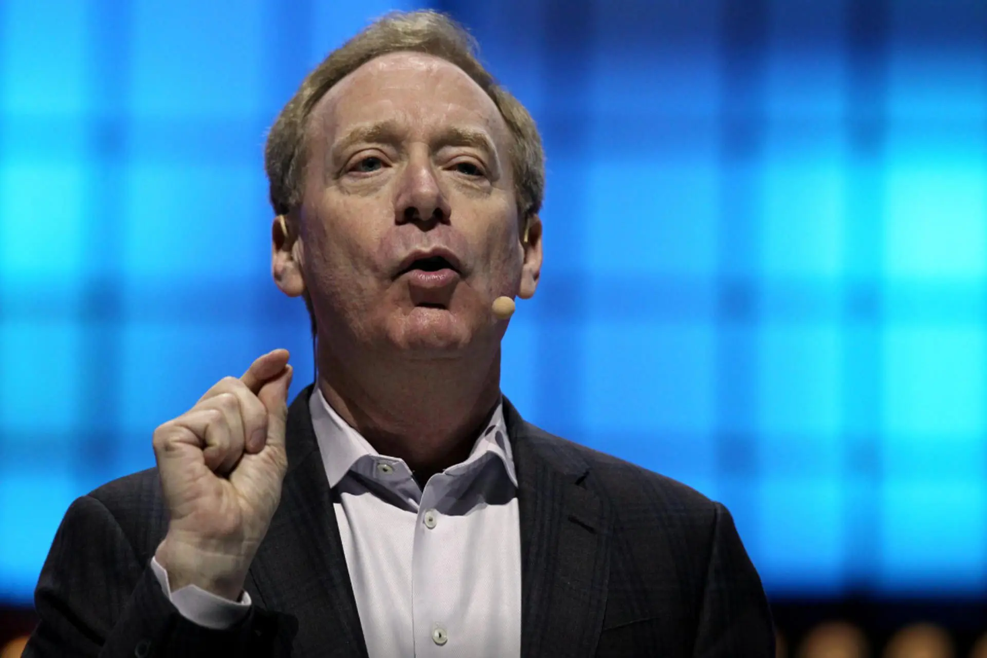 برد اسمیت رئیس مایکروسافت درحال سخنرانی در کنفرانس با میکروفون / Microsoft Brad Smith