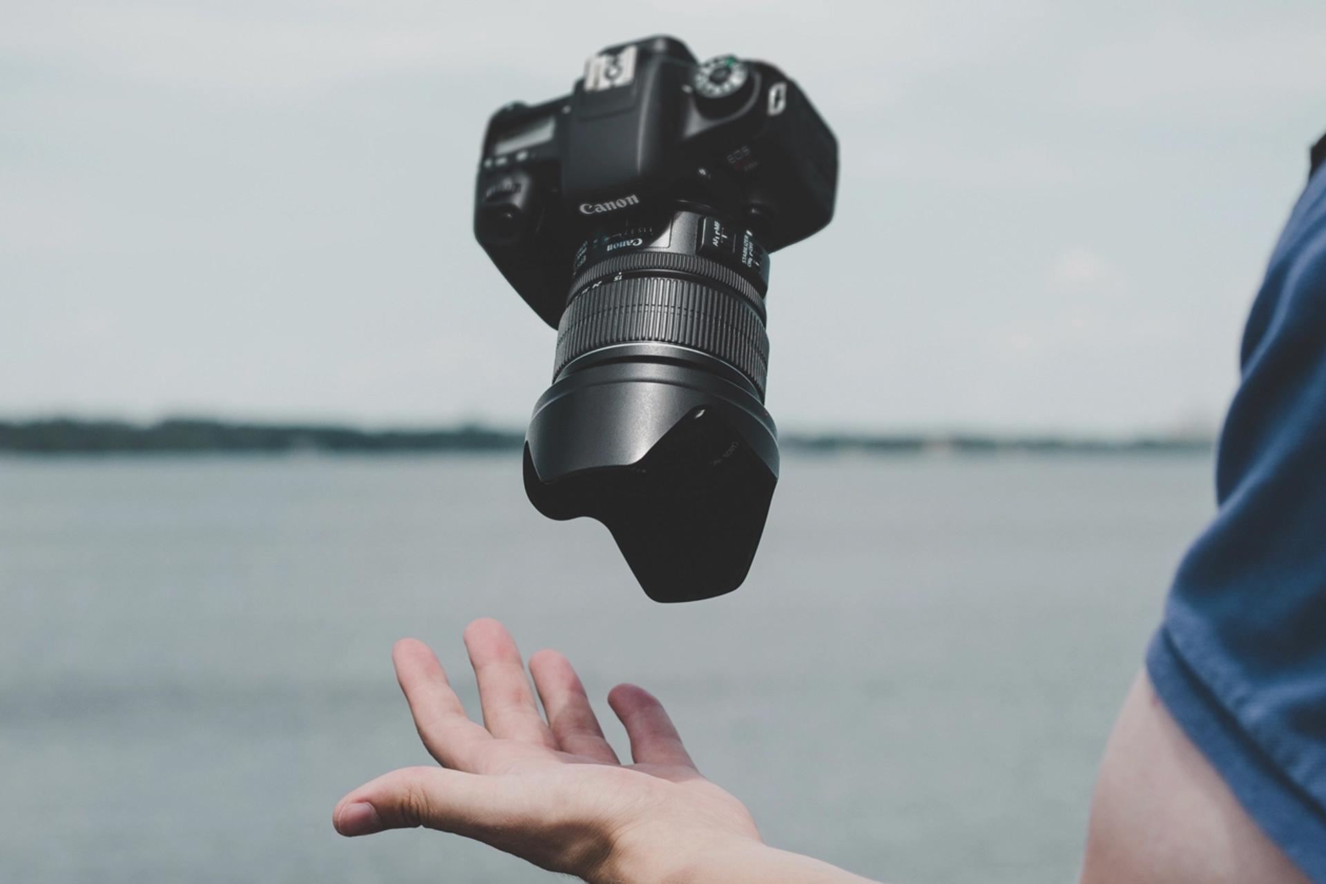 دوربین کانن ای او اس / Canon EOS از نمای بالا در بالای دست کاربر رنگ مشکی